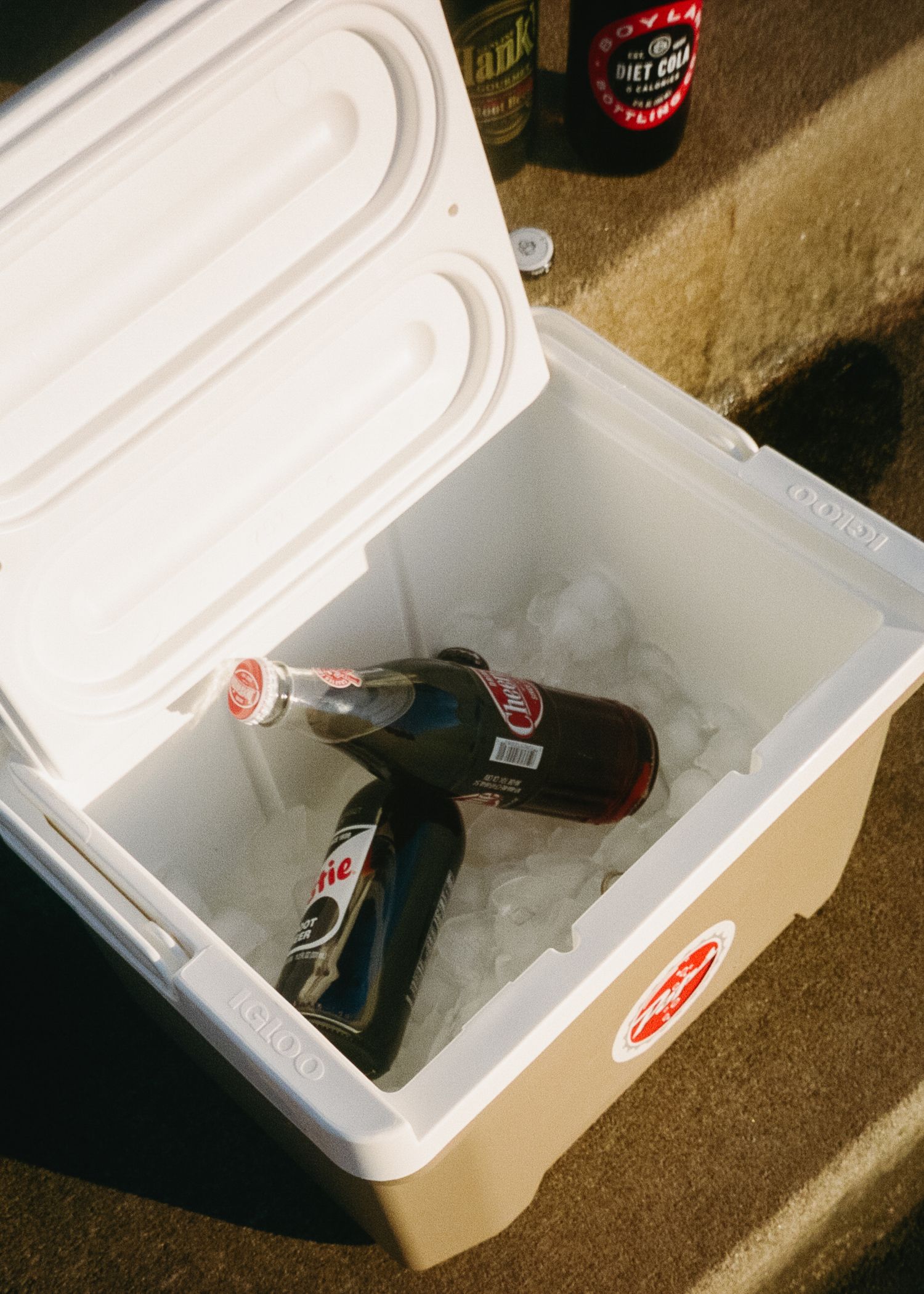 A series of photos showing a white styrofoam cooler being opened to reveal a dark object inside.