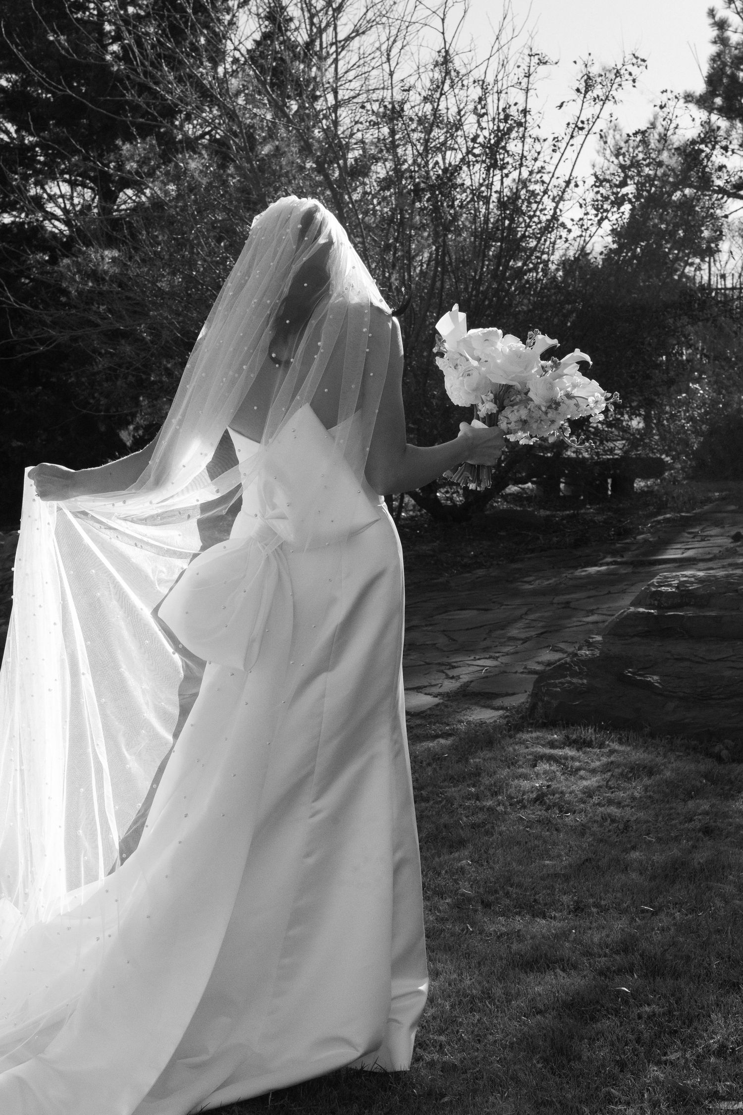 White wedding dress fabric flowing dramatically in the wind against a dark outdoor background.