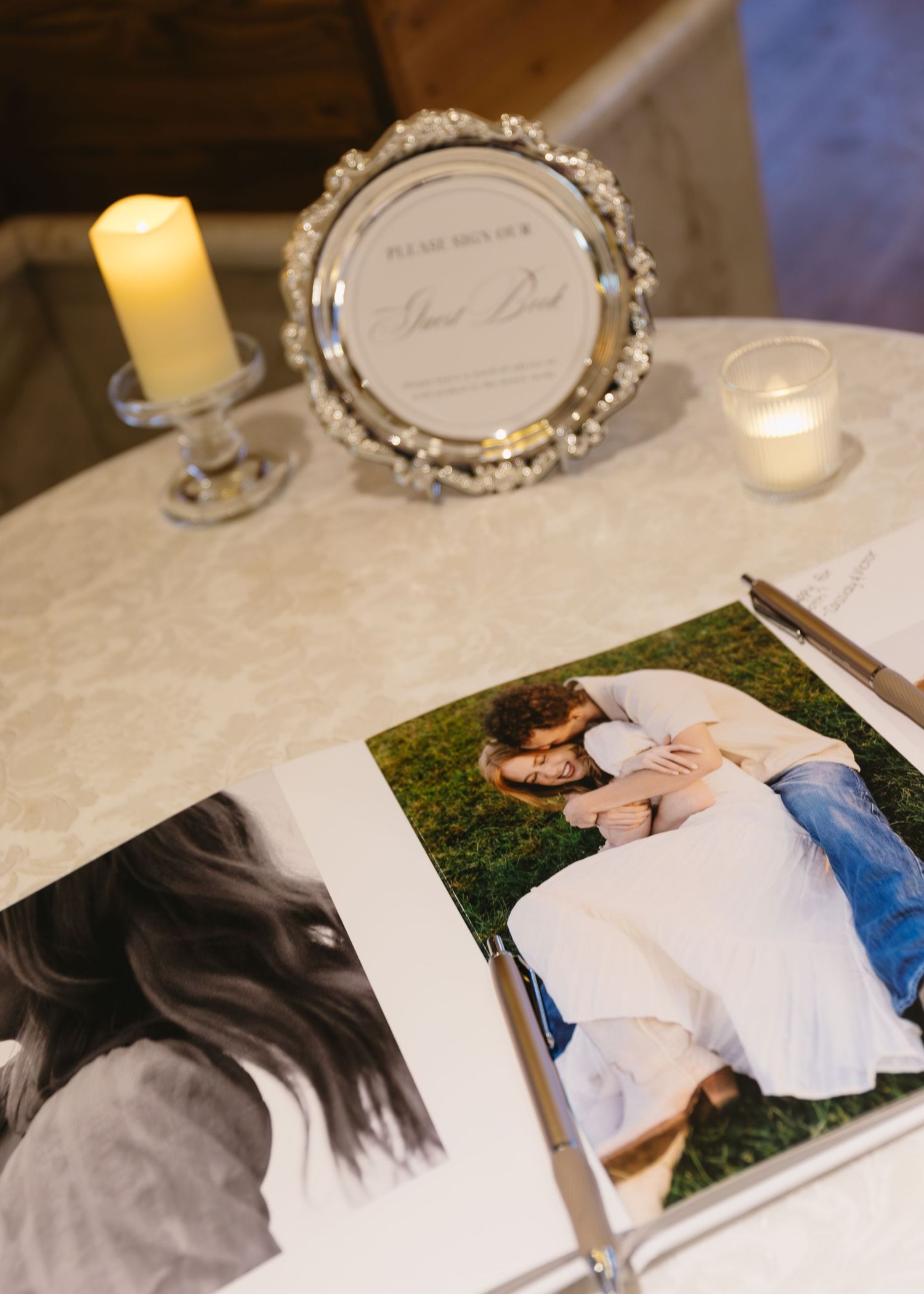 Wedding photo display on a reception table with engagement pictures and decorative frames.