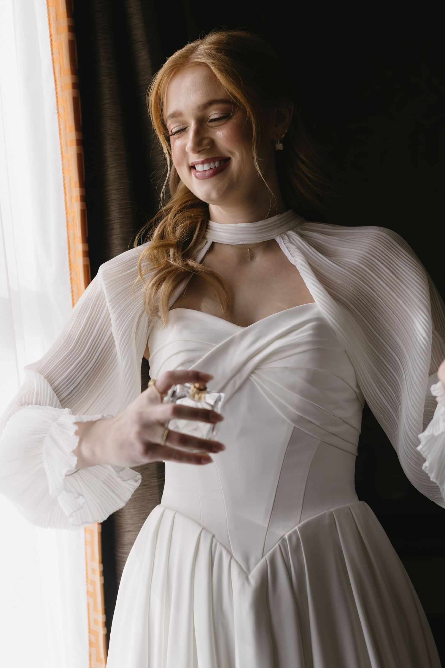 Close-up portrait shots of a bride in a white long-sleeved wedding dress against a dark background.