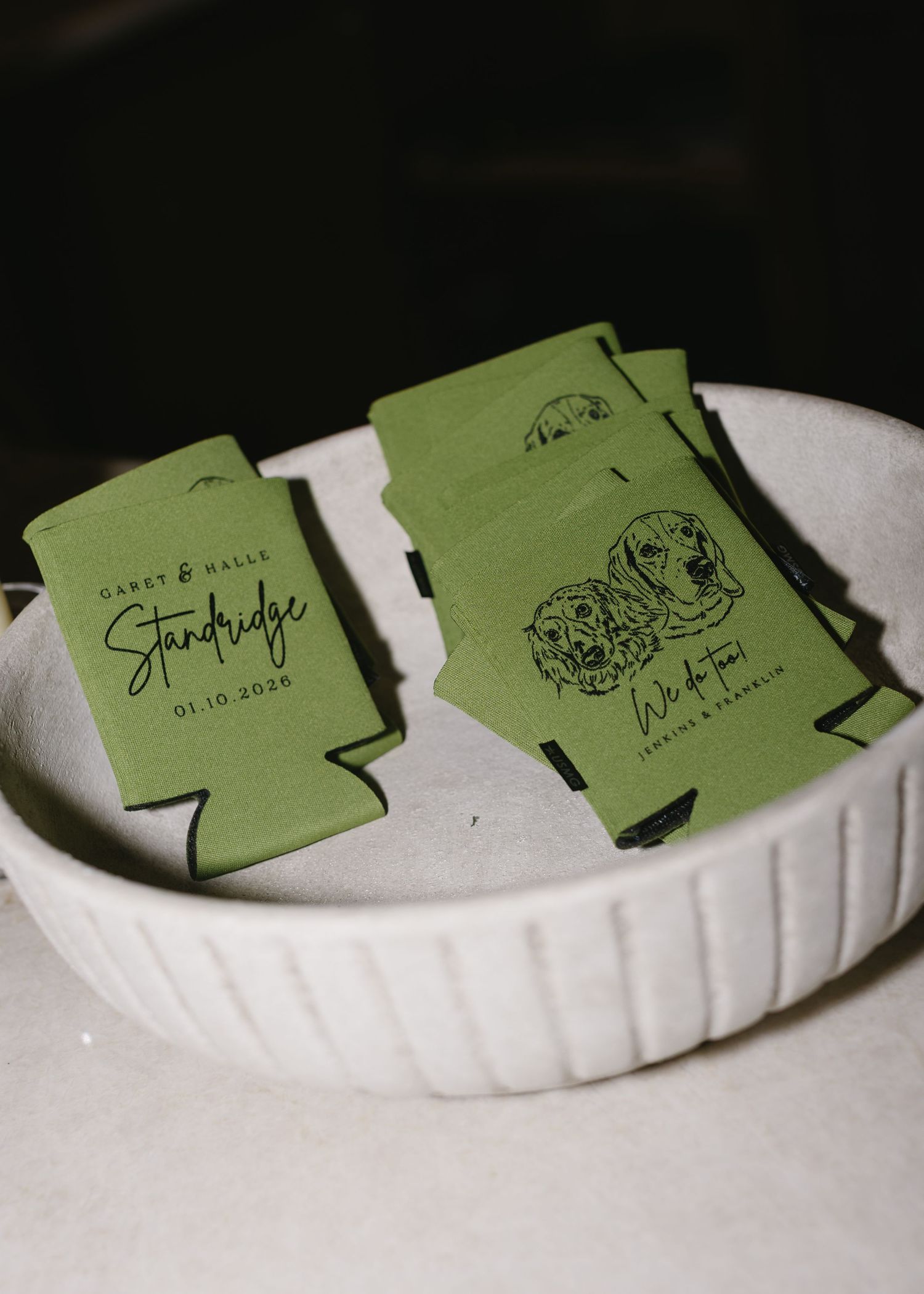 Green business cards arranged in a line on a white ceramic surface.