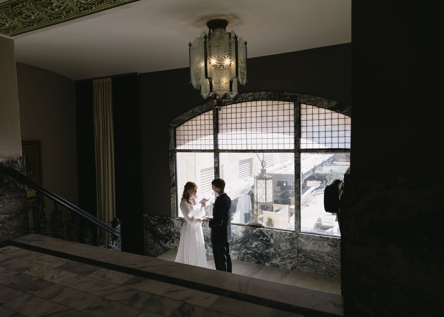 Dark silhouette of wedding venue interior with dramatic lighting and architectural details.