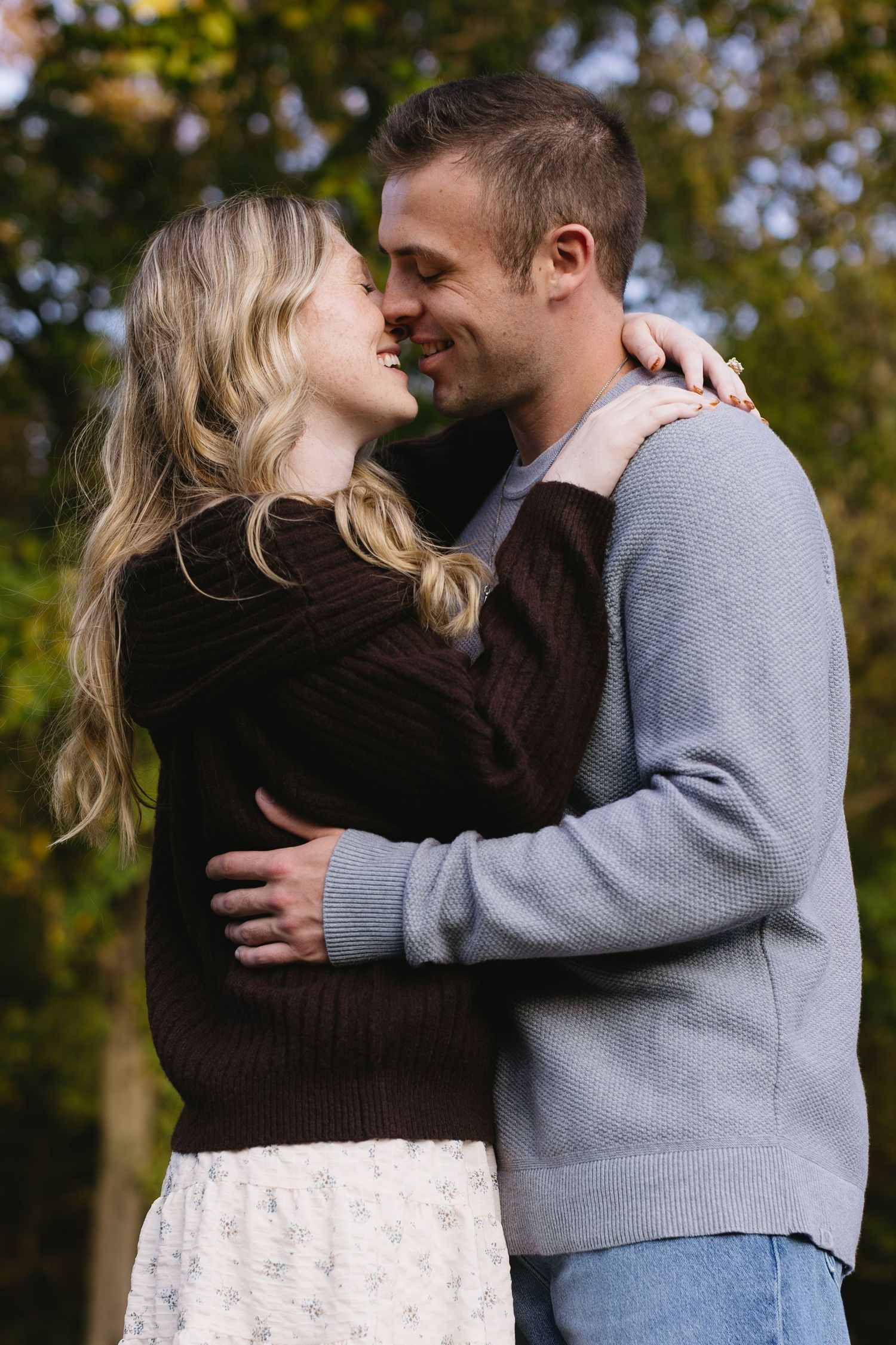 A tender embrace captured during an autumn outdoor photoshoot.