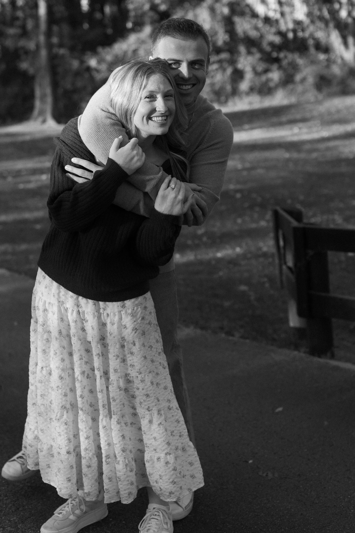 A playful black and white photo sequence of a couple embracing and laughing together outdoors.