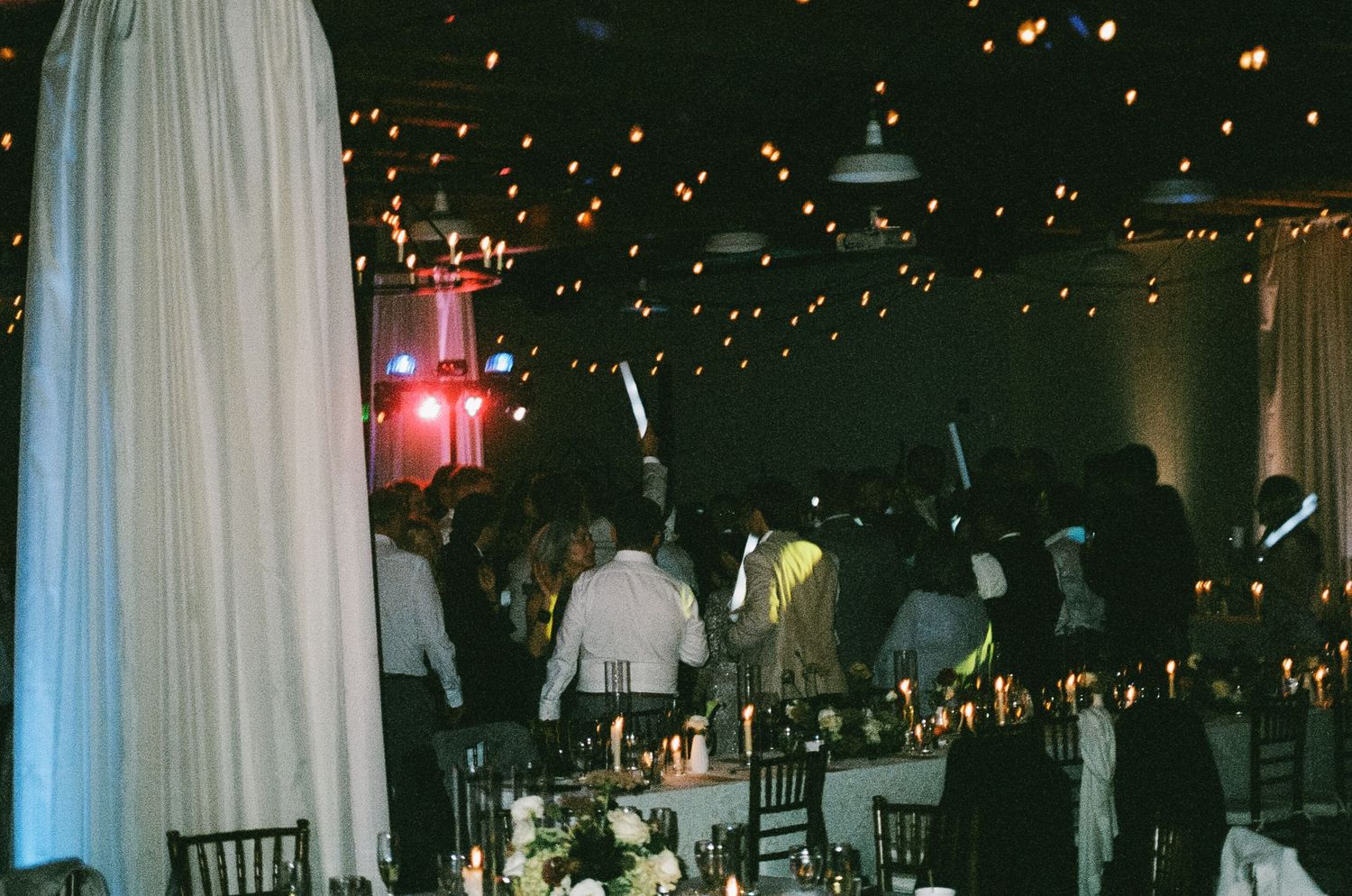 Wedding reception venue with white drapes and twinkling lights creating an elegant ambiance.