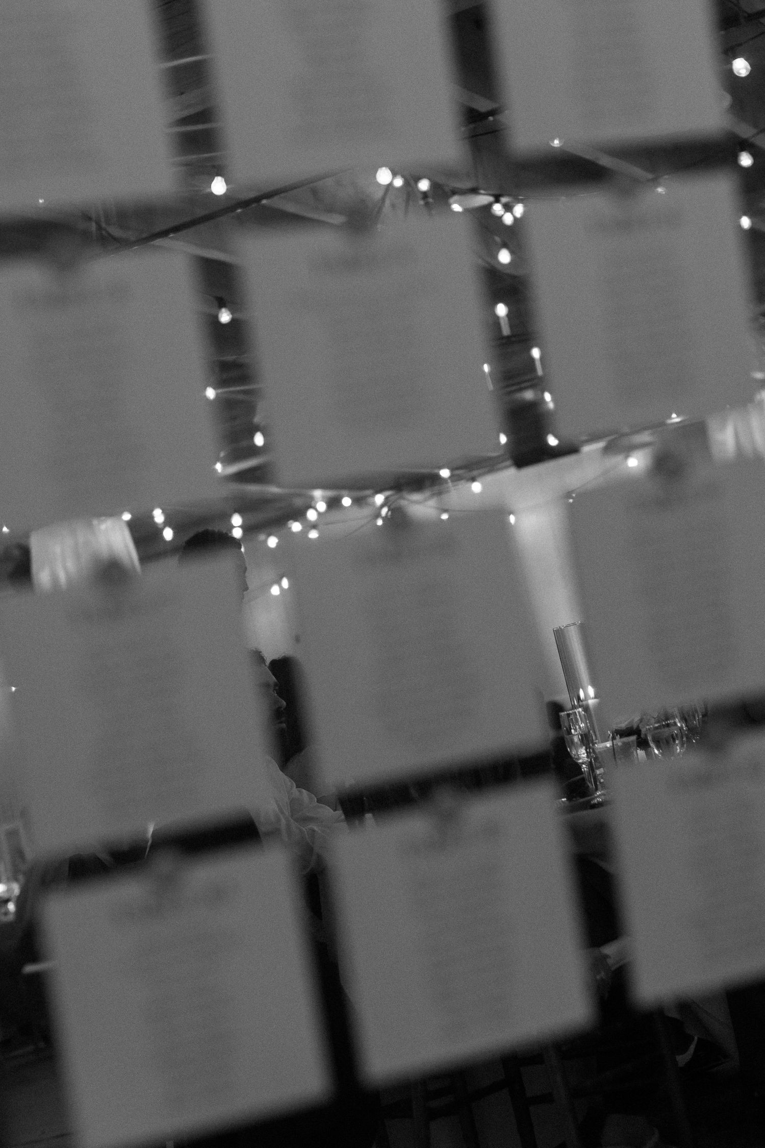 String lights creating a dreamy ambiance against a dark background at wedding reception.