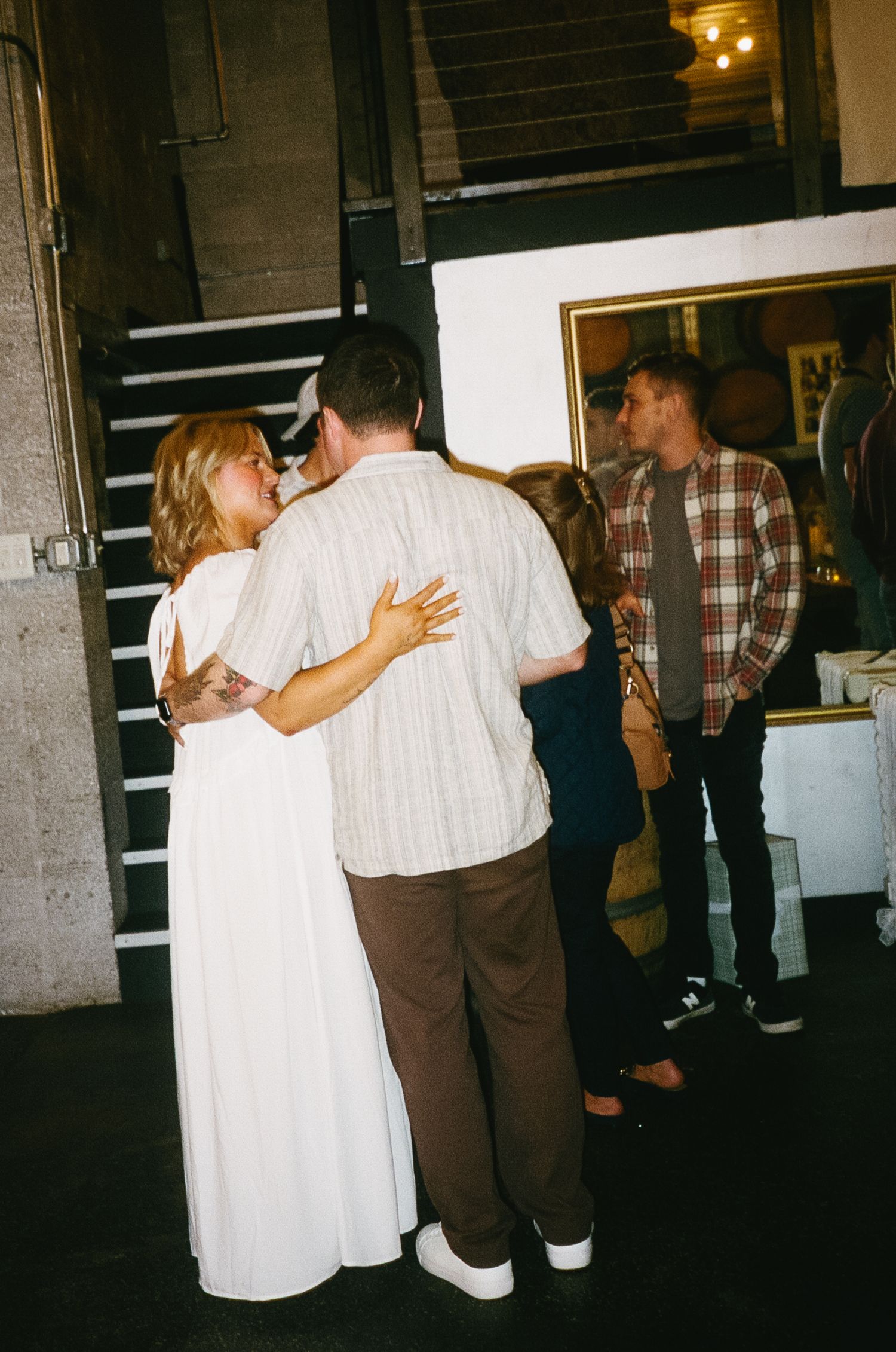 Couples dancing together in a dimly lit venue space.