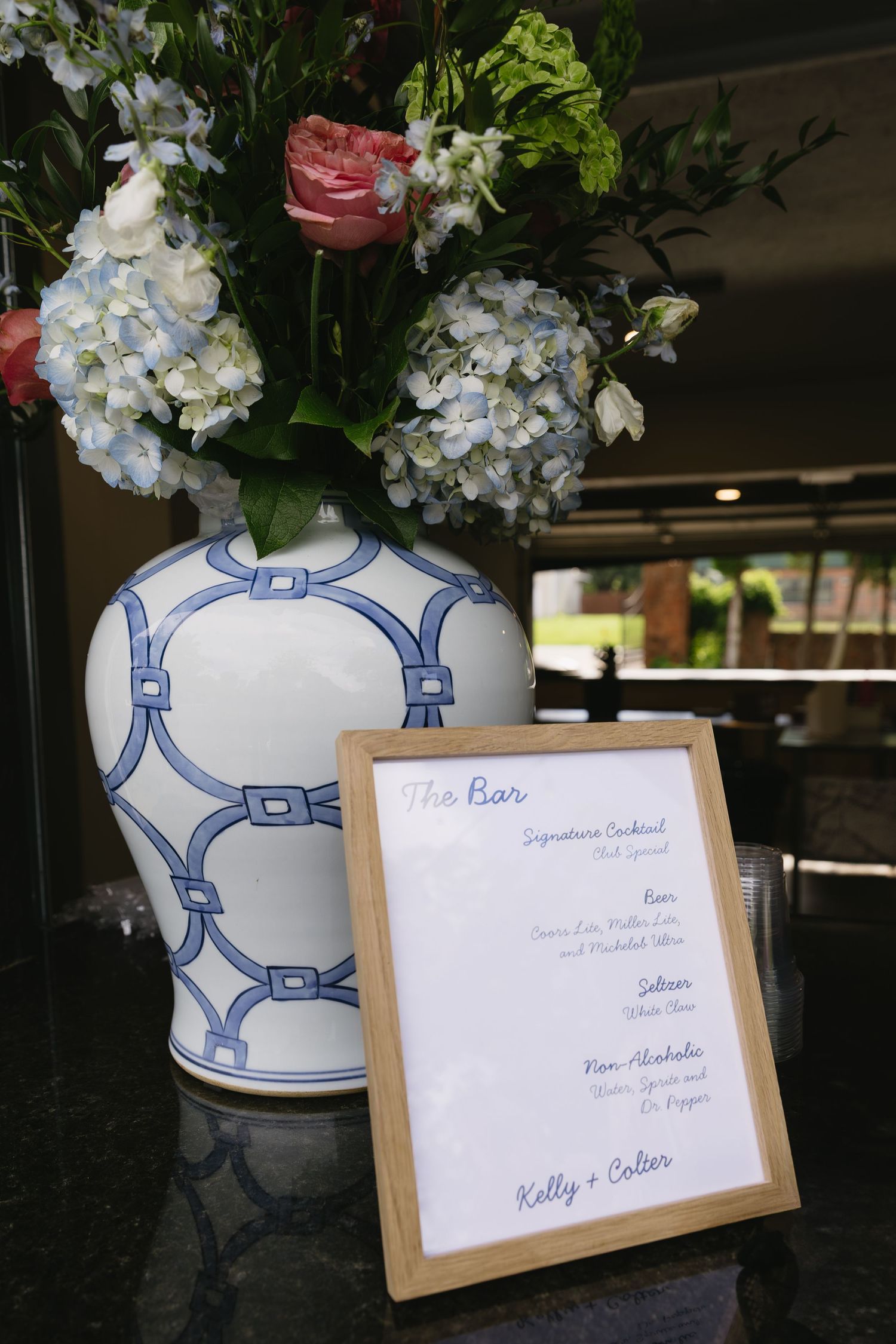 Blue and white porcelain vases with floral arrangements and wooden place cards on a dark surface.
