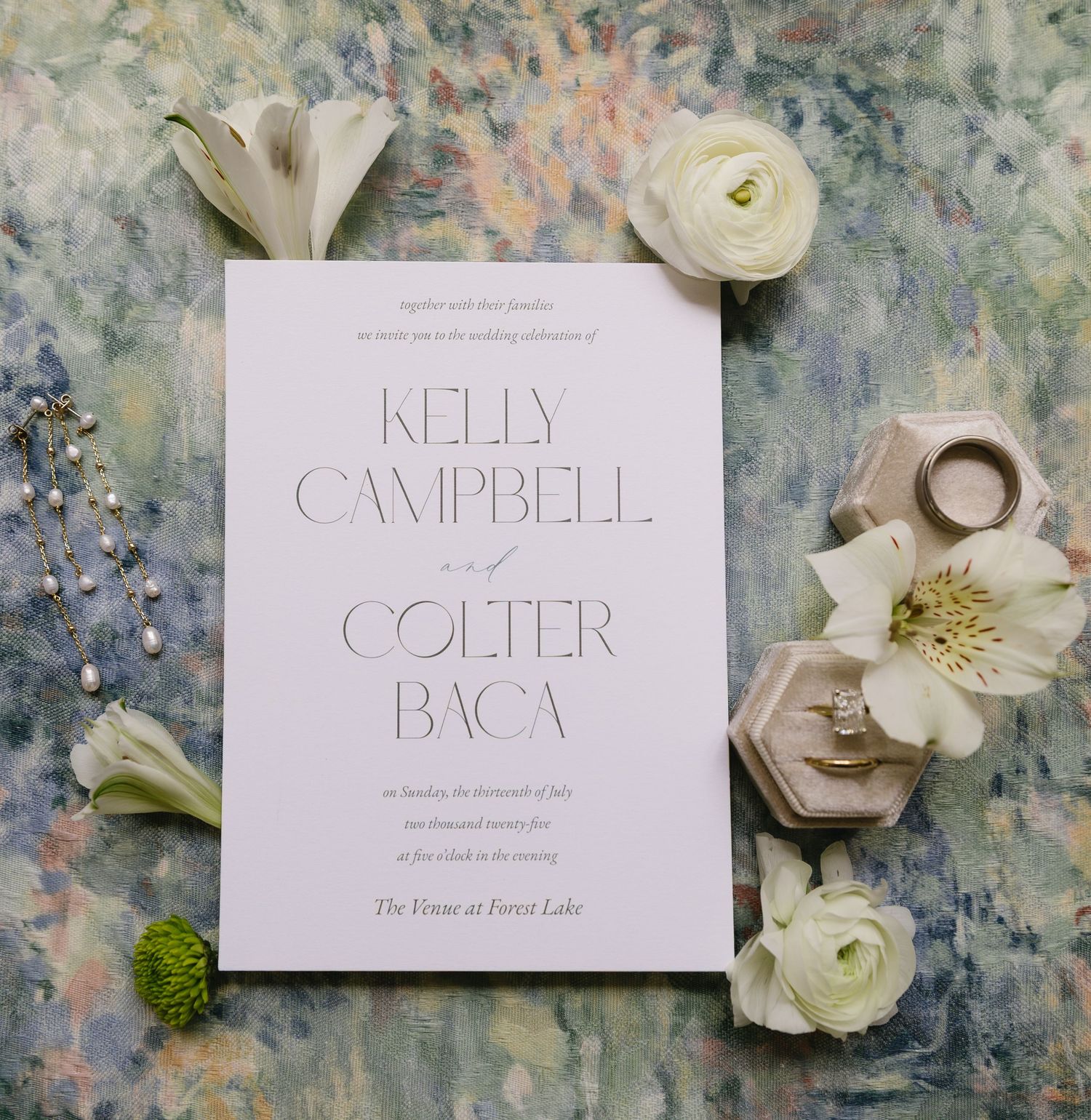 Elegant name cards and delicate white flowers arranged on a textured gray surface for a sophisticated wedding design.
