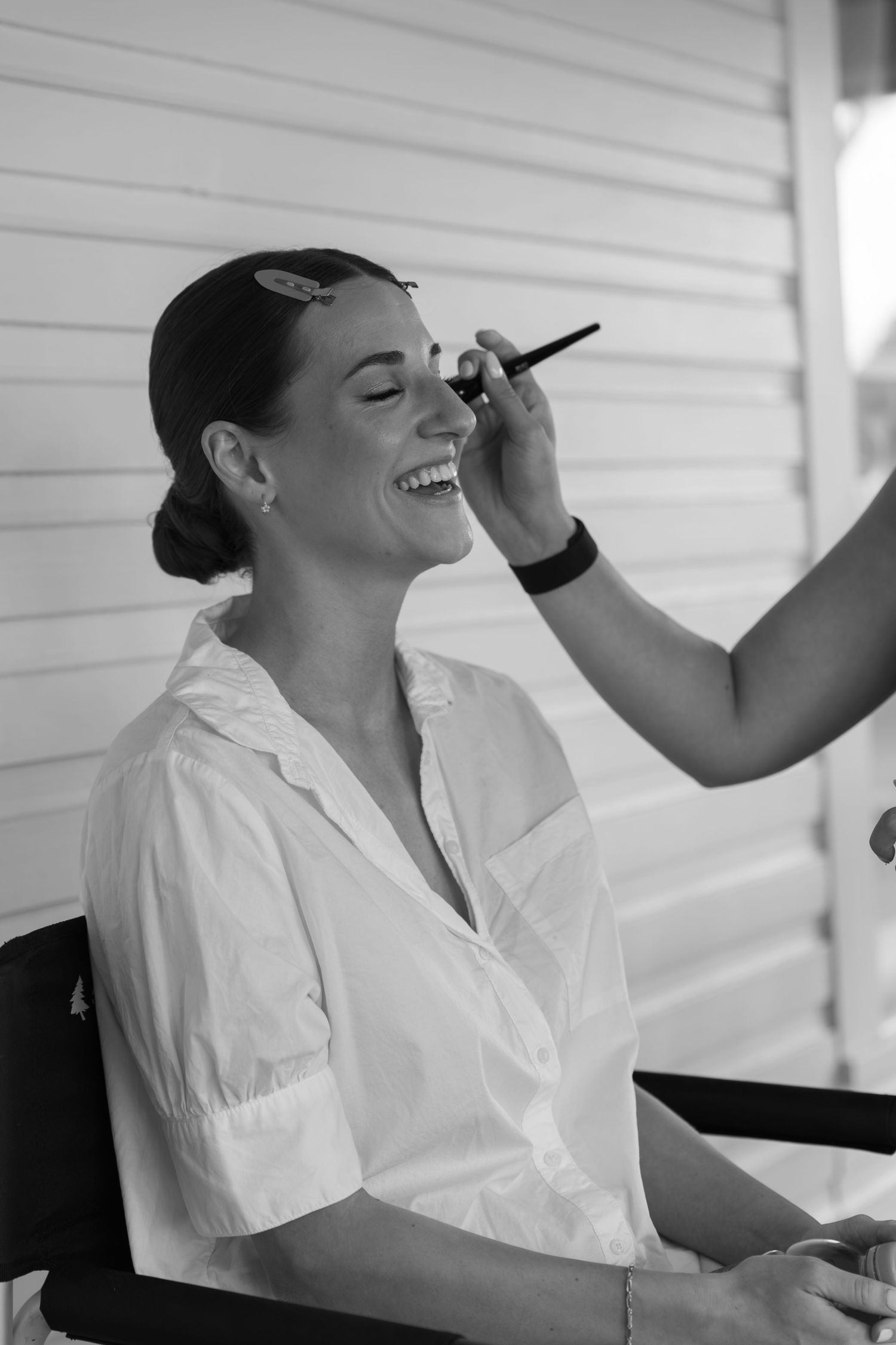 Black and white photos showing preparation with makeup being applied in natural light.