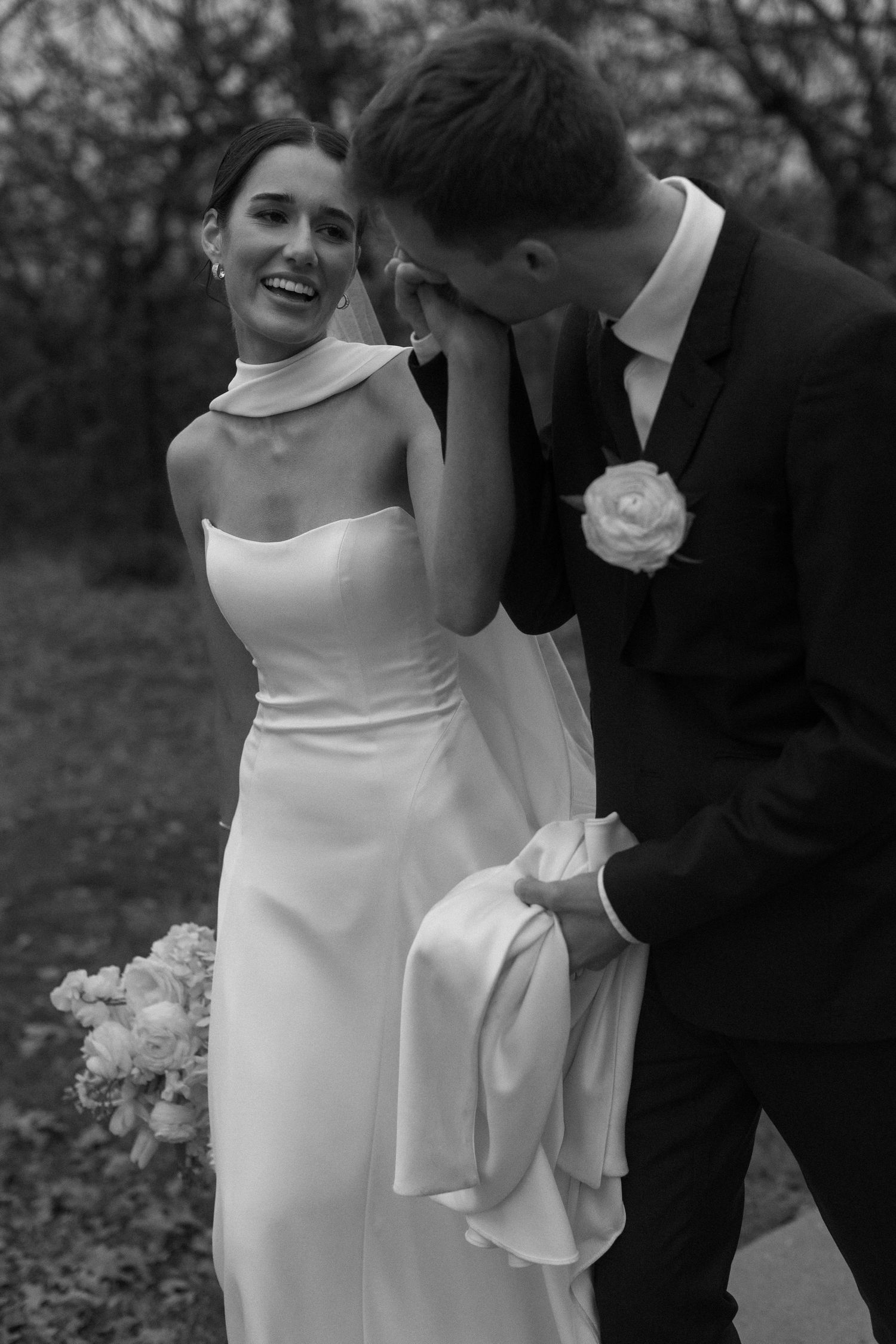 A candid black and white wedding photo capturing a joyful moment between newlyweds.