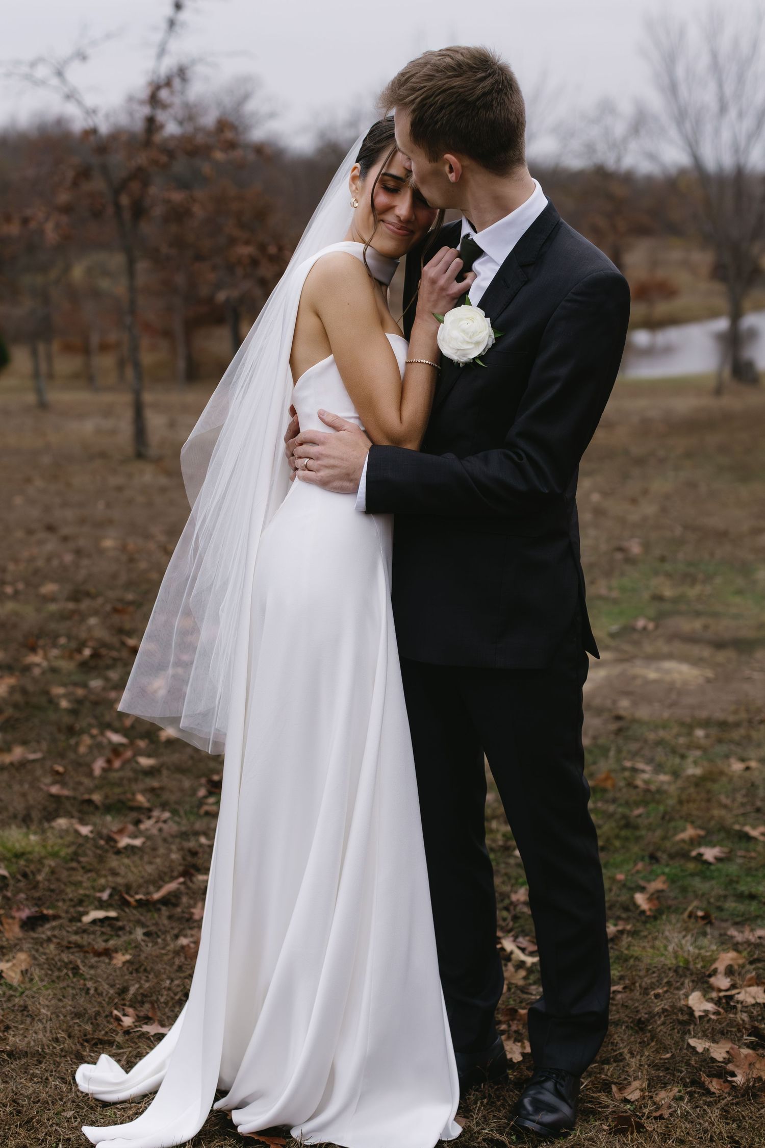 Romantic wedding portraits in an autumn field with flowing white dress and veil.