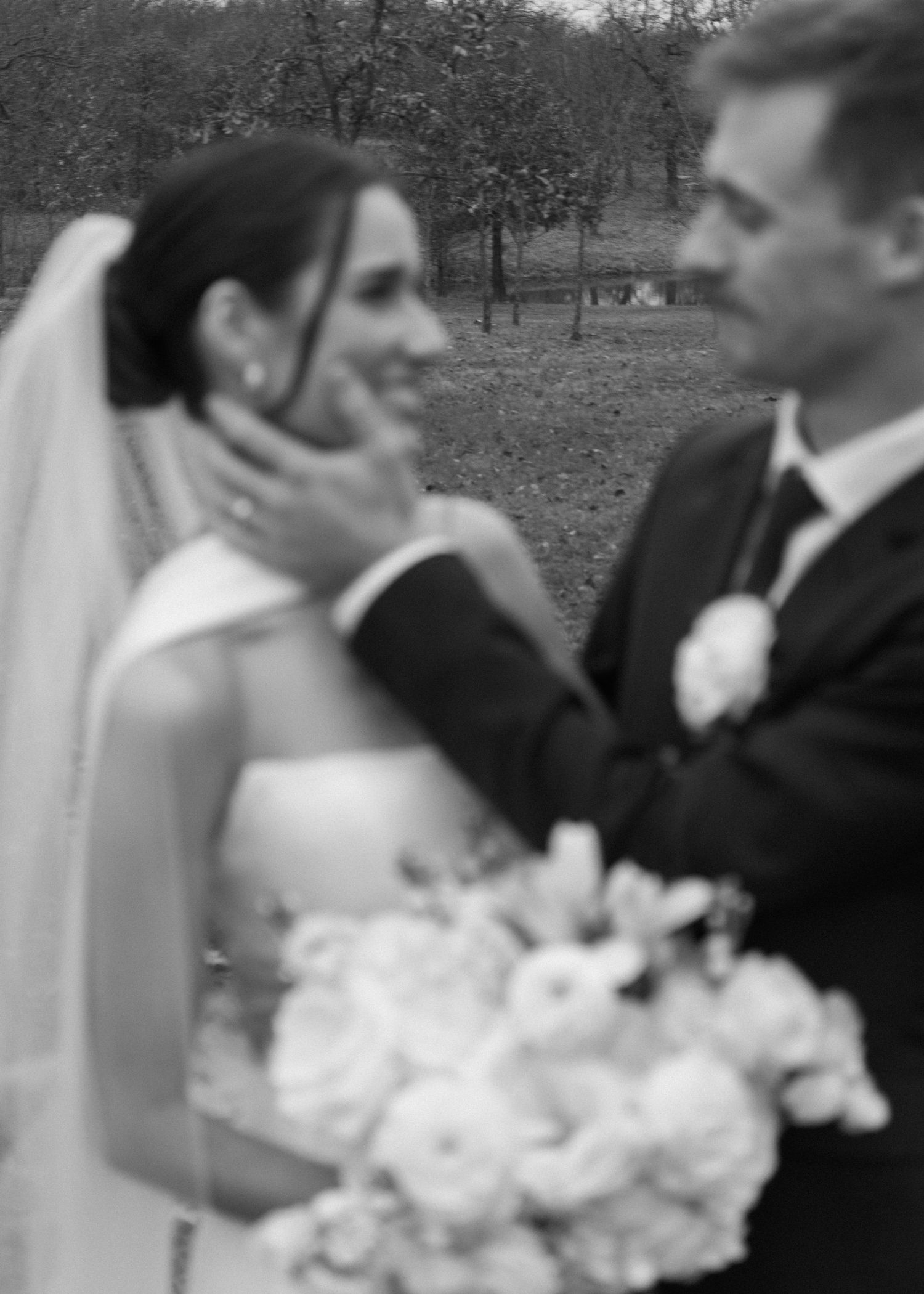A romantic black and white moment between newlyweds with a white floral bouquet.