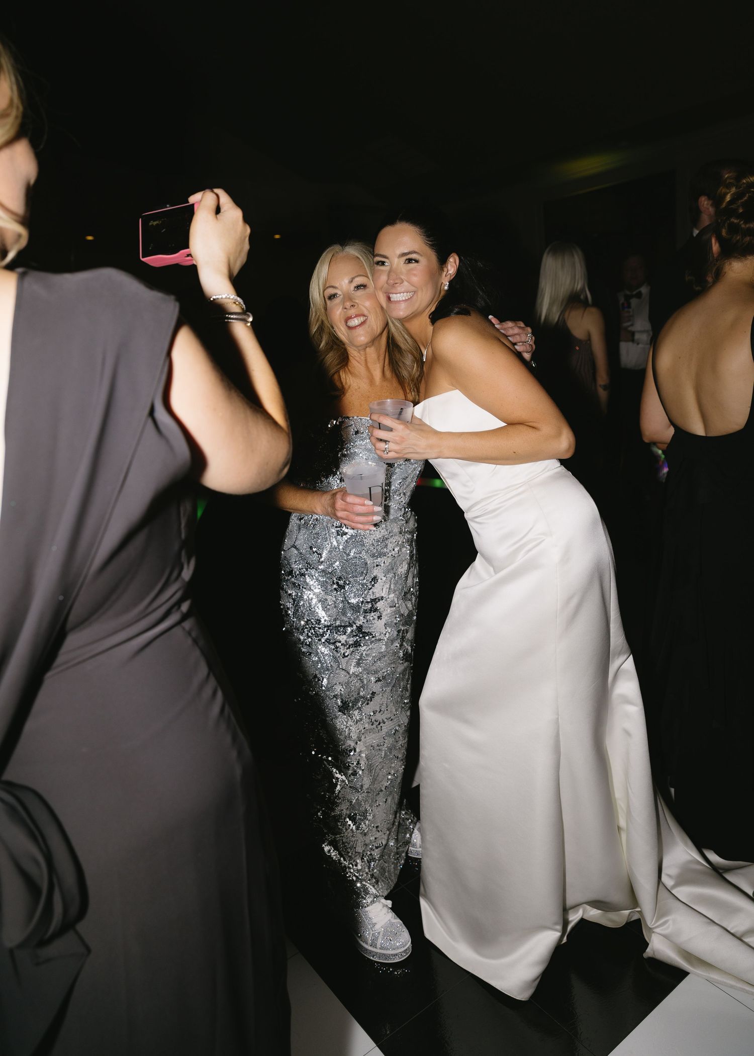 Wedding guests dancing and celebrating in formal attire at evening reception.