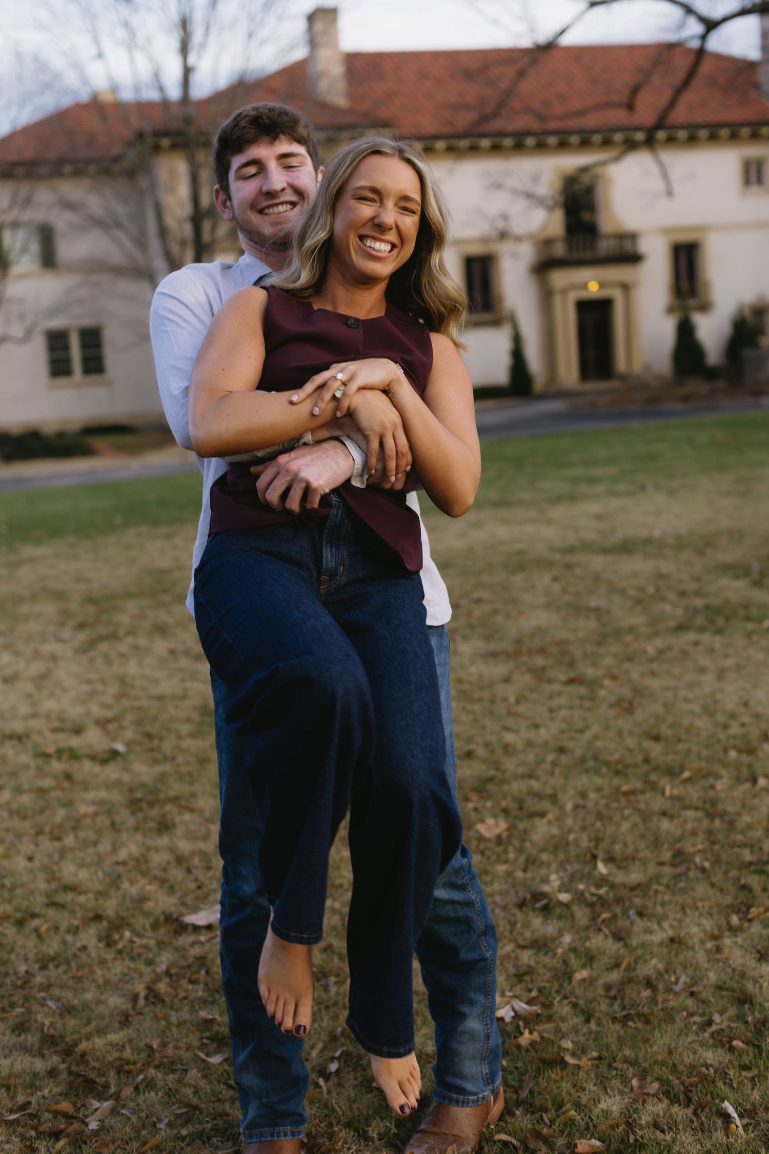 A romantic moment captured between a couple embracing outdoors near historic buildings.