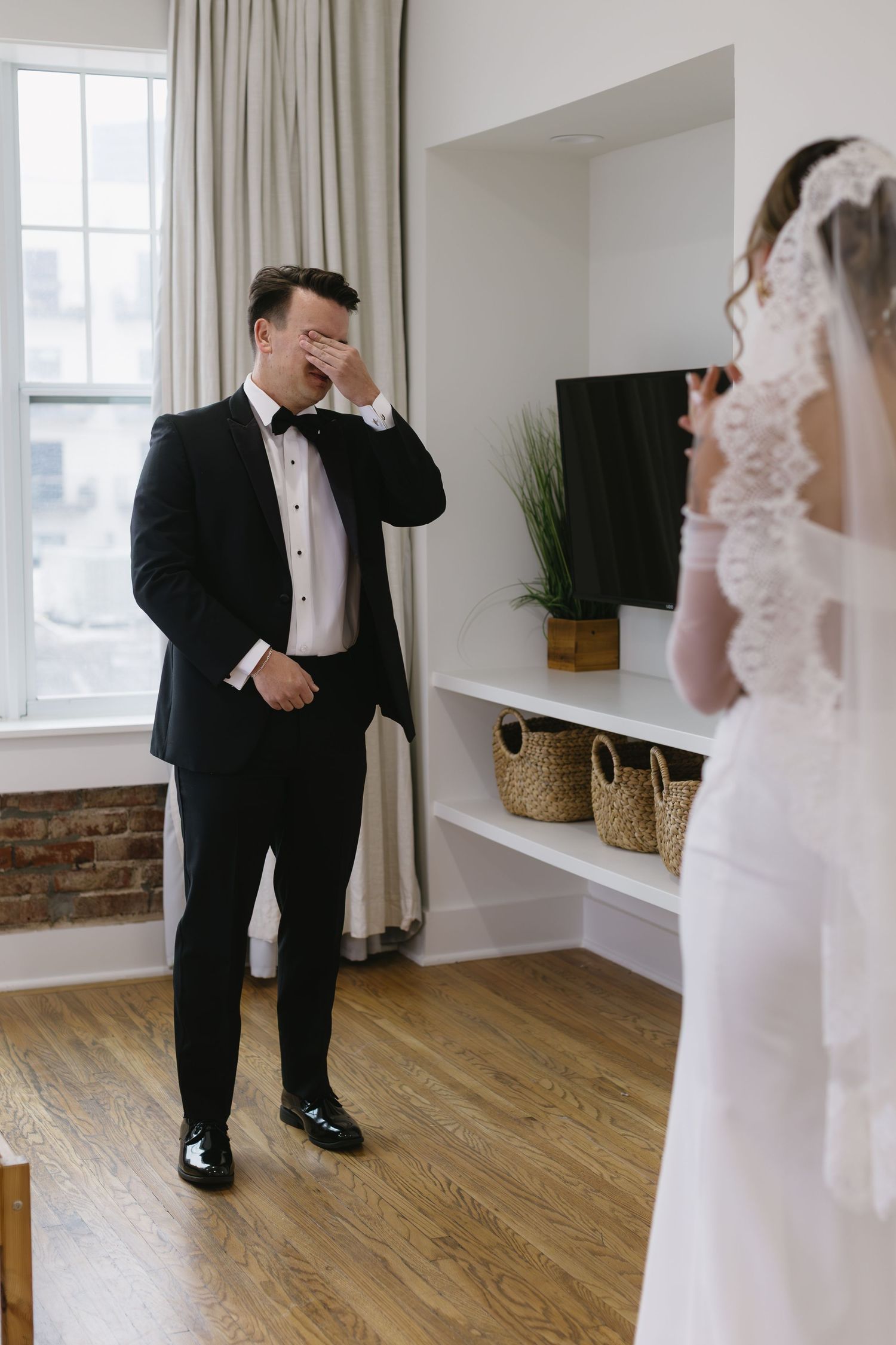 A first look moment between a couple on their wedding day in a bright modern room.