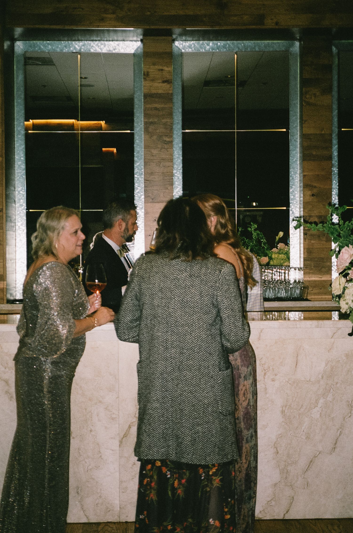 Guests mingling at a marble bar during an evening reception.