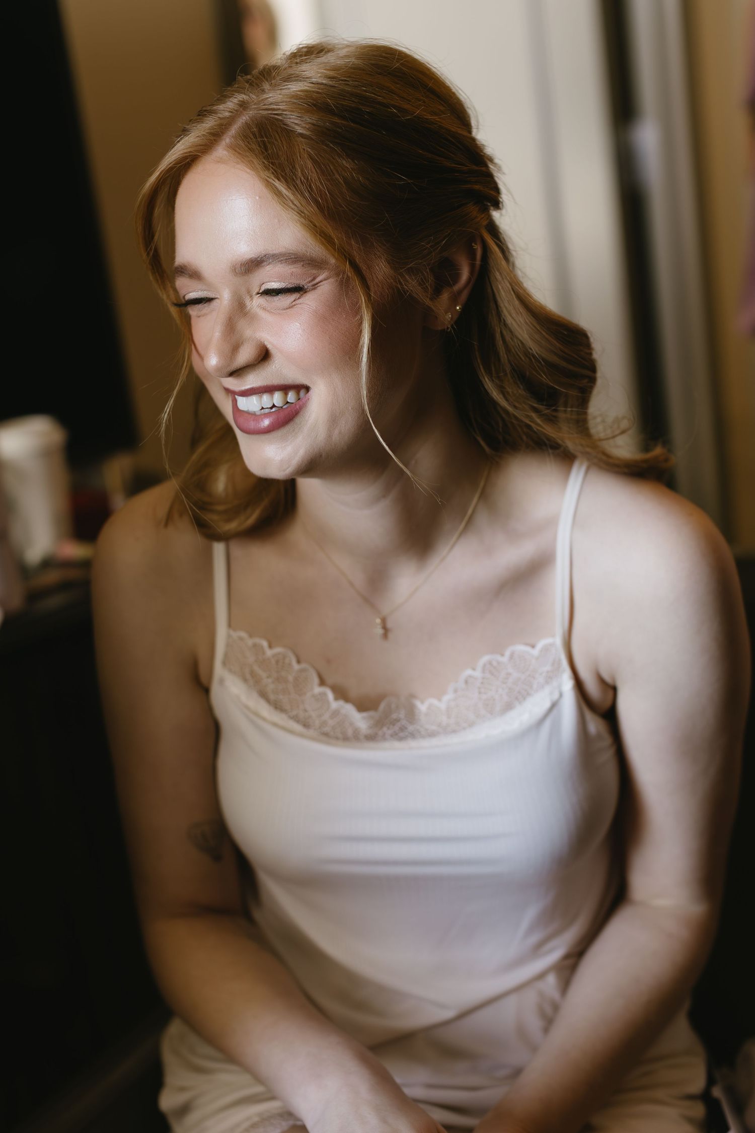 Close up shots of someone in a white camisole smiling and looking away from camera.