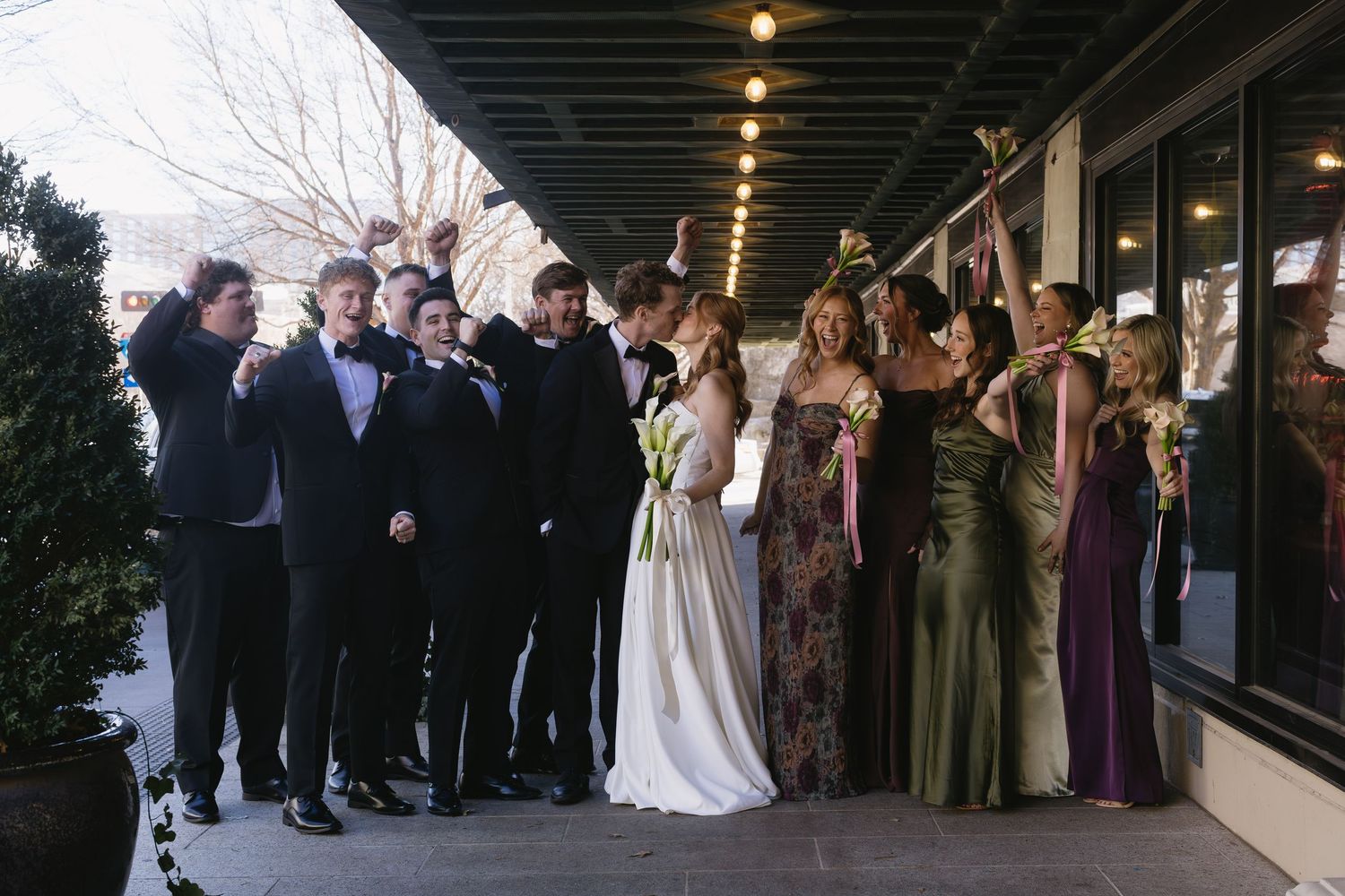 Wedding ceremony guests gathered in formal attire under industrial venue lighting.