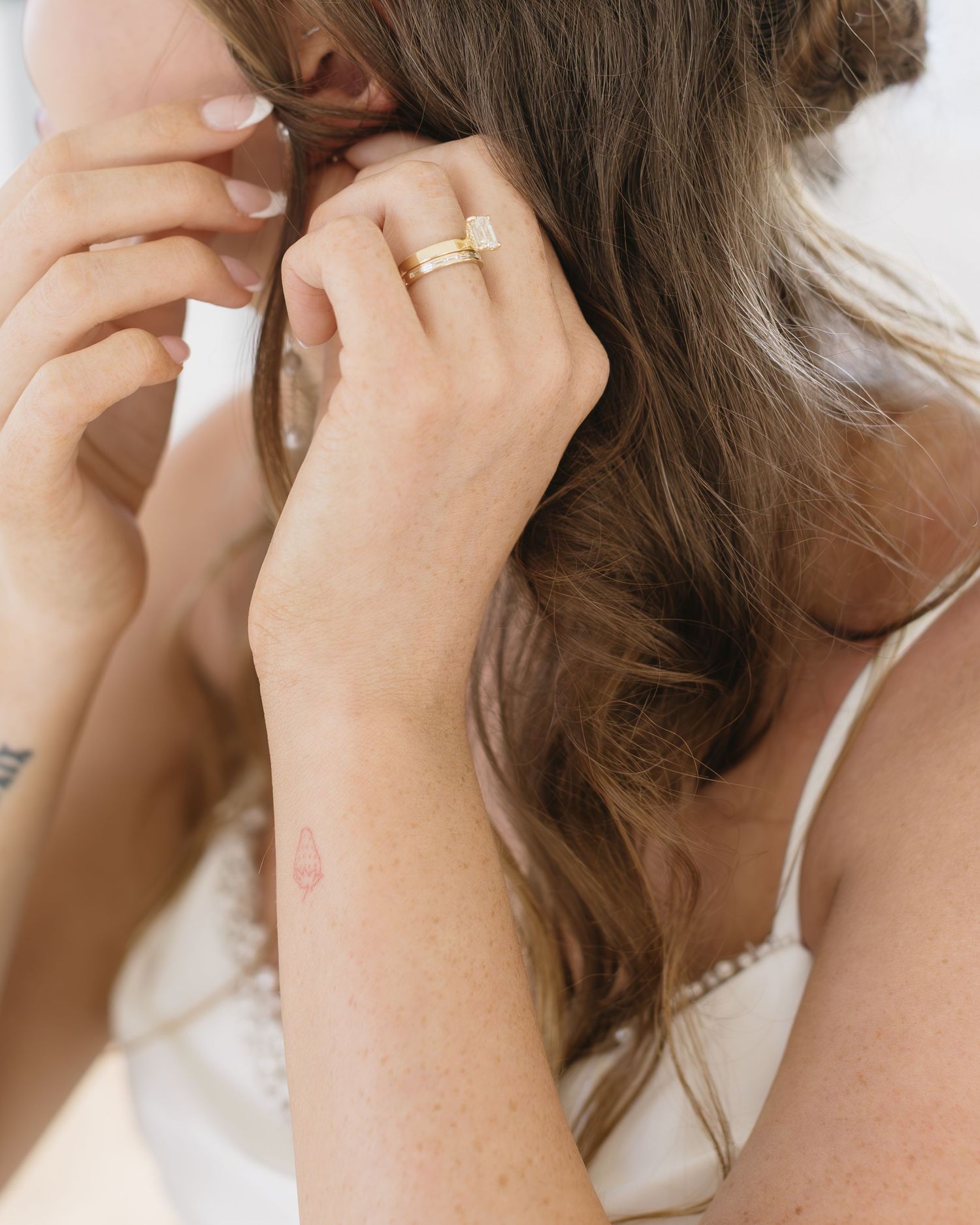 Close-up series of someone braiding a section of long brown hair into a french braid pattern.