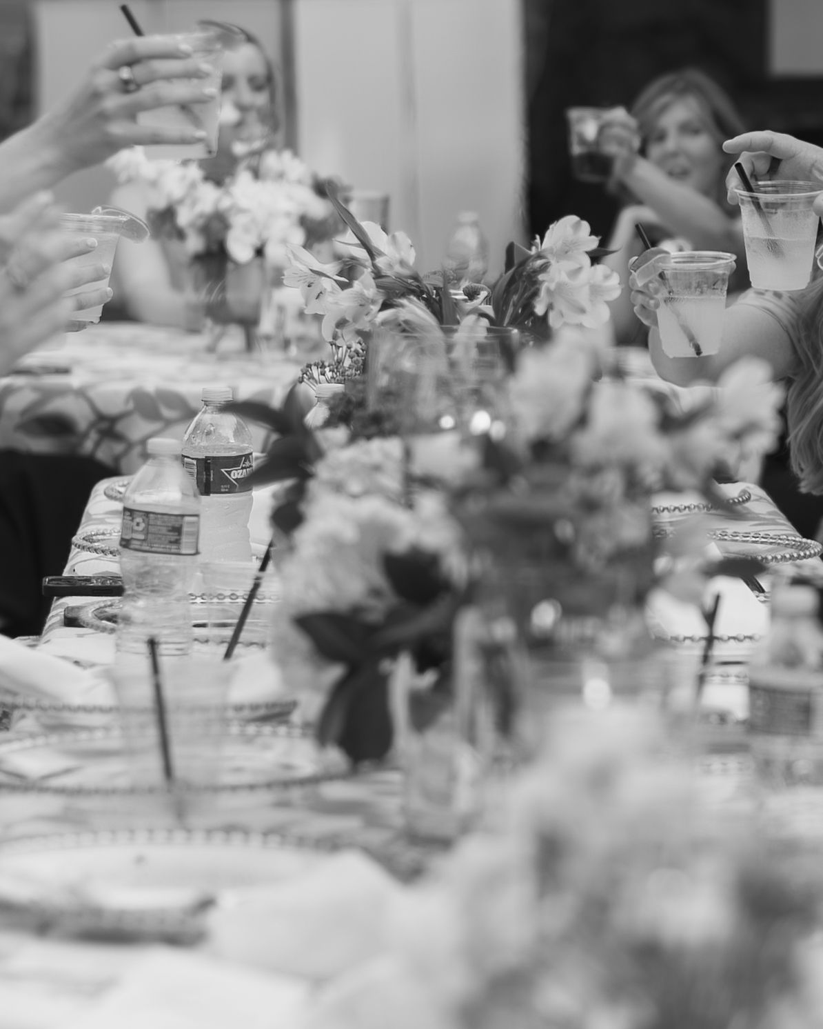 Black and white reception table with flower centerpieces and place settings.