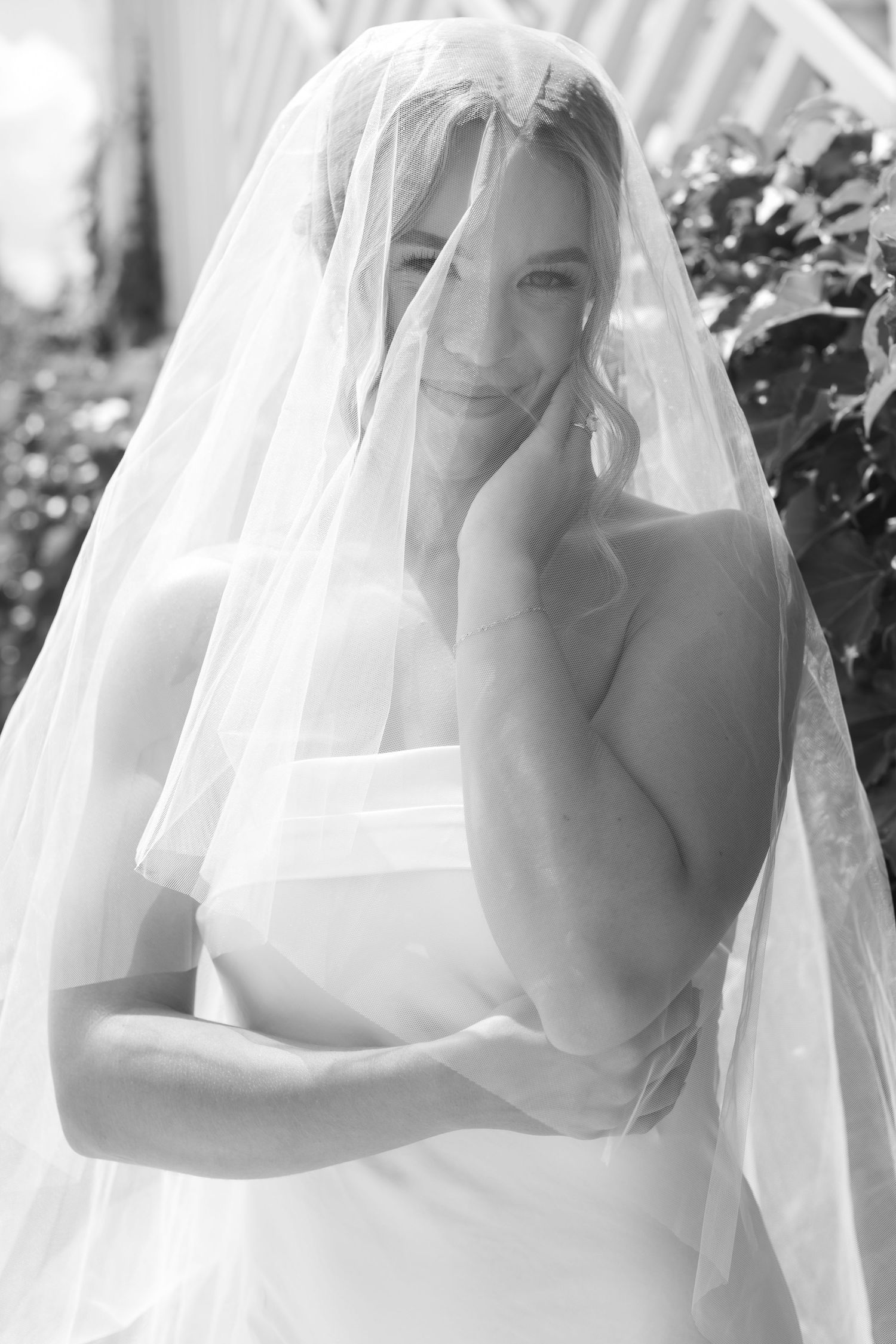 Black and white portrait sequence of a bride wearing a delicate veil against a soft background.