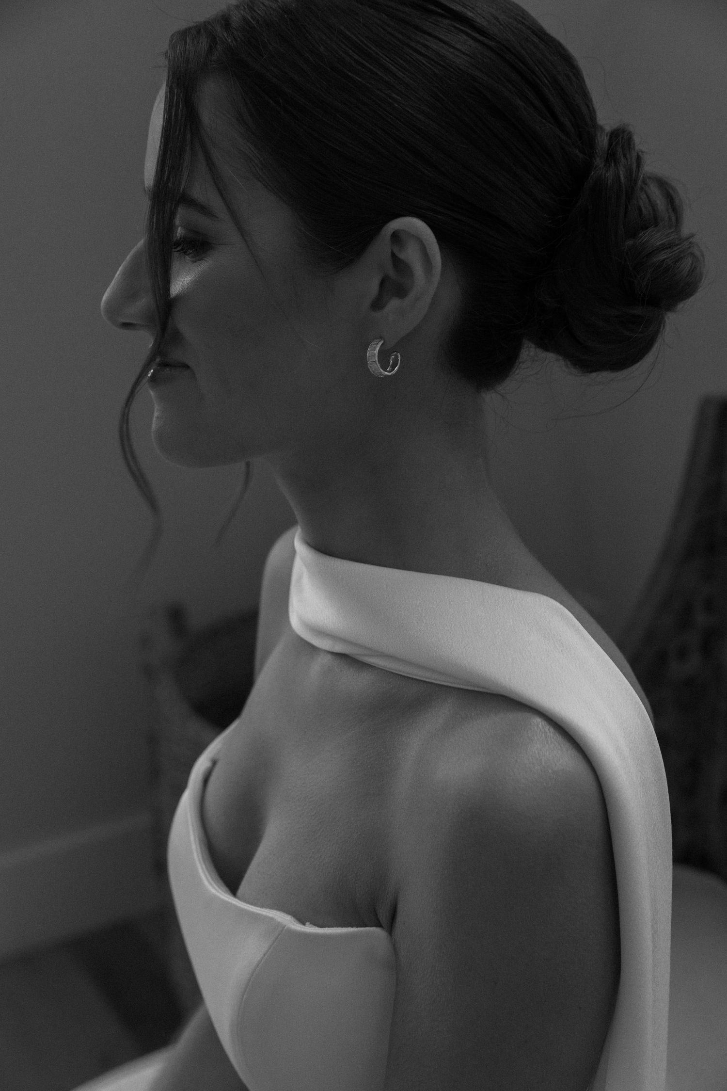 Artistic black and white portraits showcasing the elegant neckline of a wedding dress.