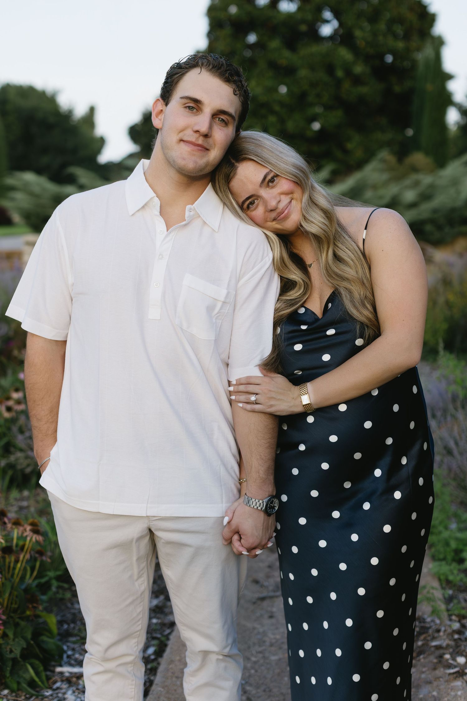 Garden portraits showing tender moments in contrasting polka dot and white ensembles.