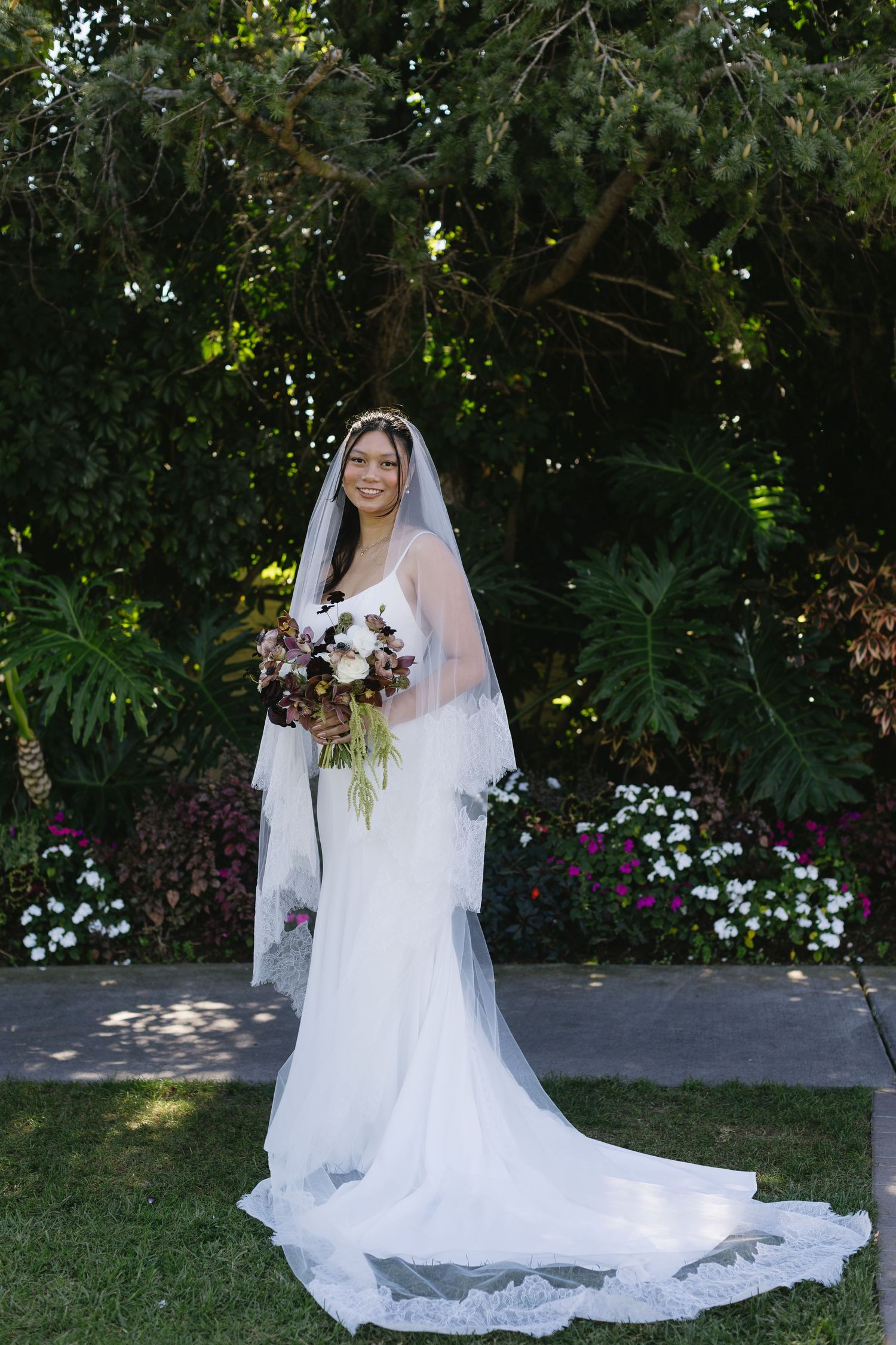 Beautiful bridal portraits in a garden setting with a flowing white dress and veil.