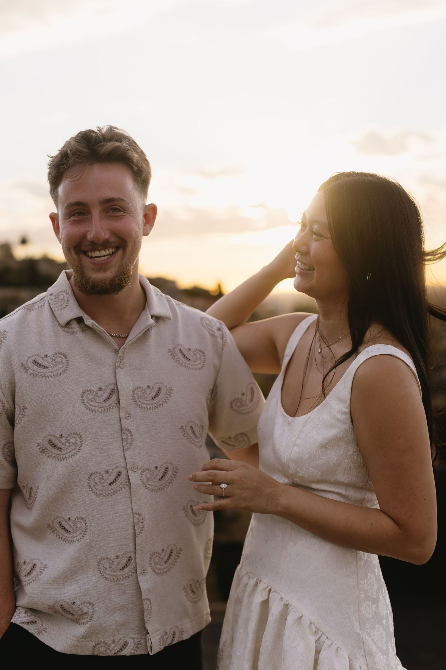 A couple shares a romantic moment outdoors during golden hour photography session.