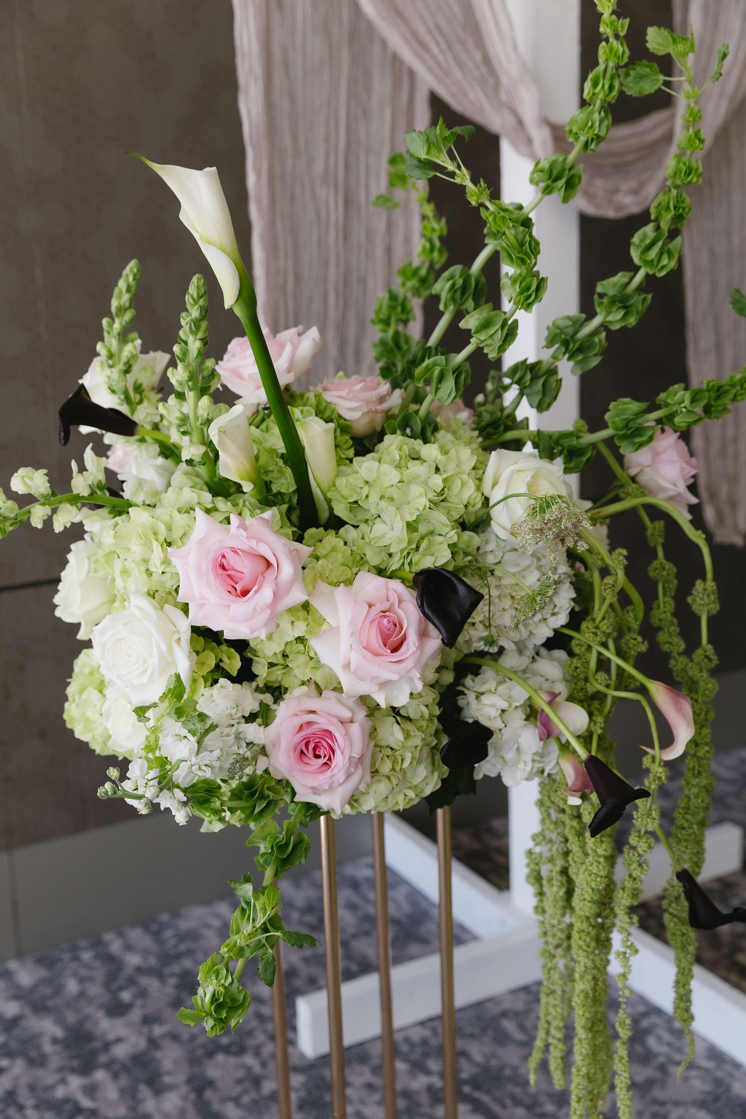 Elegant floral arrangements featuring pink roses and white hydrangeas with cascading greenery.