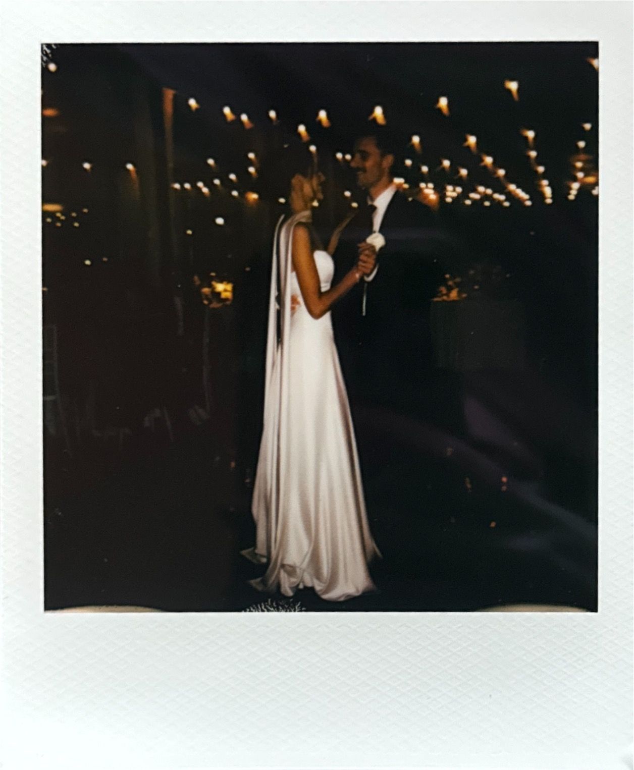 Evening wedding reception with string lights creating romantic ambiance.
