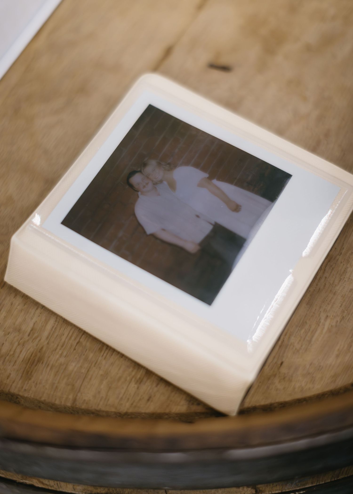 White photo prints displayed on a wooden surface with vintage styling.
