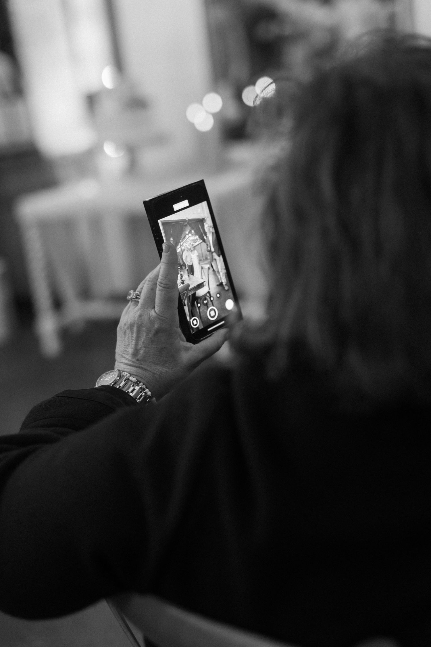 Black and white photo of guests taking pictures at an evening celebration.