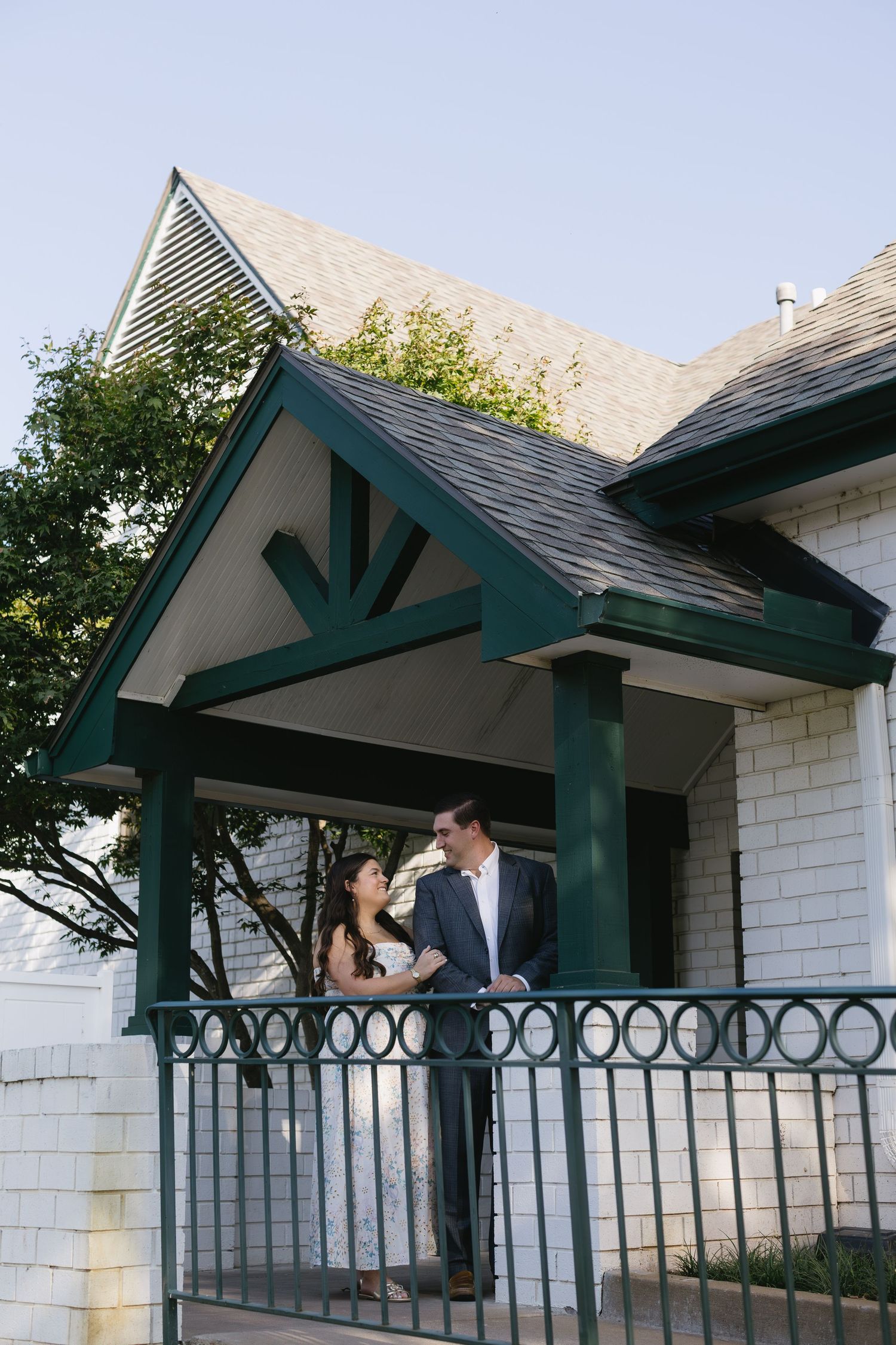Close-up sequence of a covered patio entrance with green posts and ornate metal railing against white stone walls.