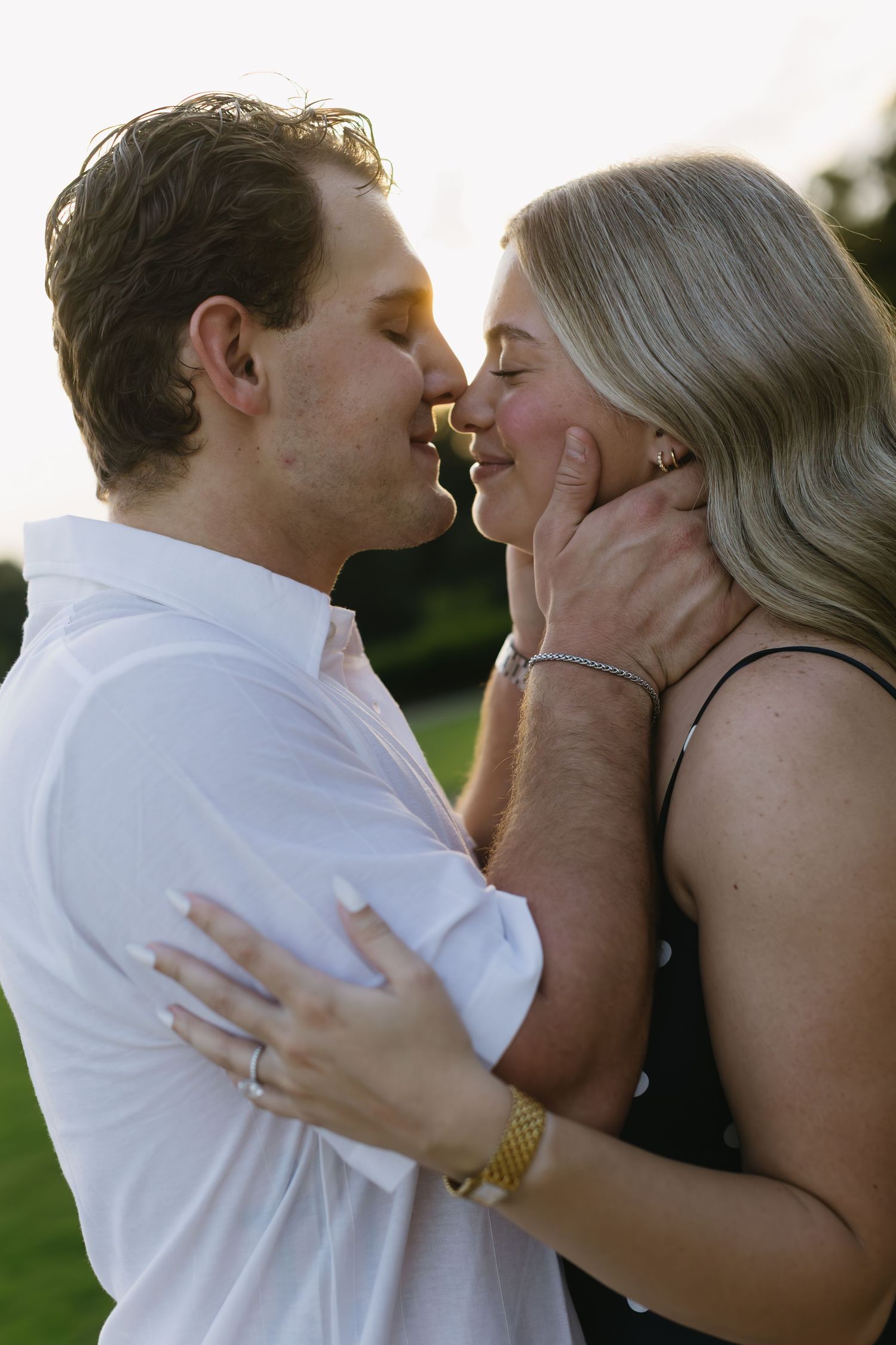 A romantic sequence of photos capturing a tender kiss between a couple during sunset, with golden light in the background.