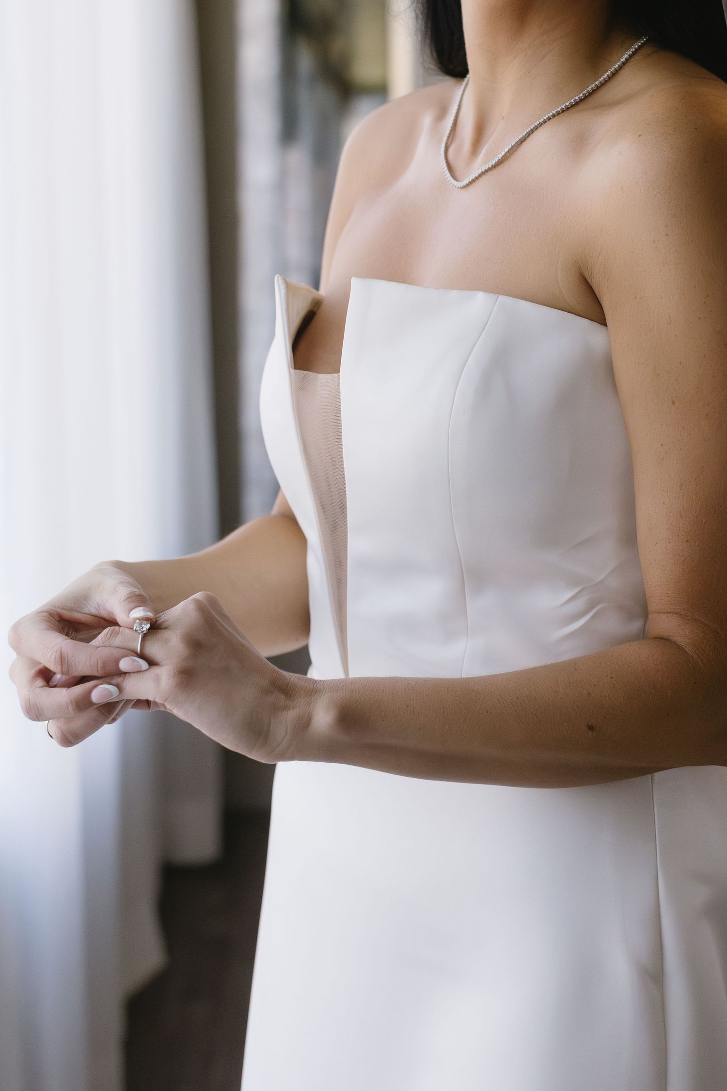 Close-up of elegant white wedding dress with strapless neckline.