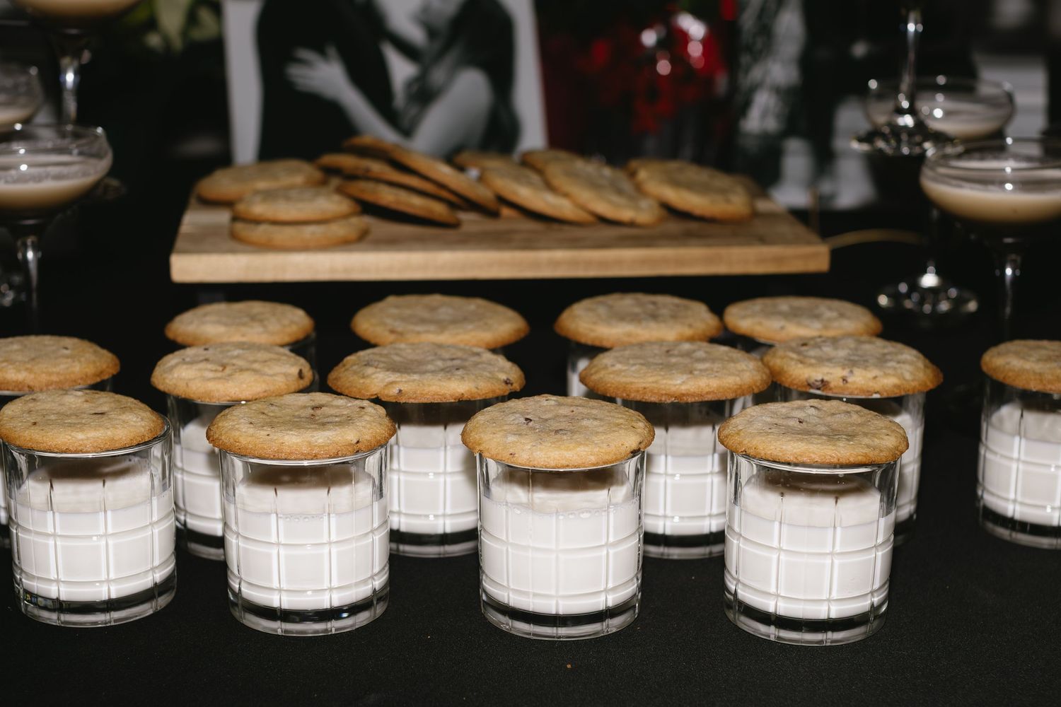White ceramic jars with cork lids arranged in a row on a wooden surface display a minimalist kitchen storage solution.