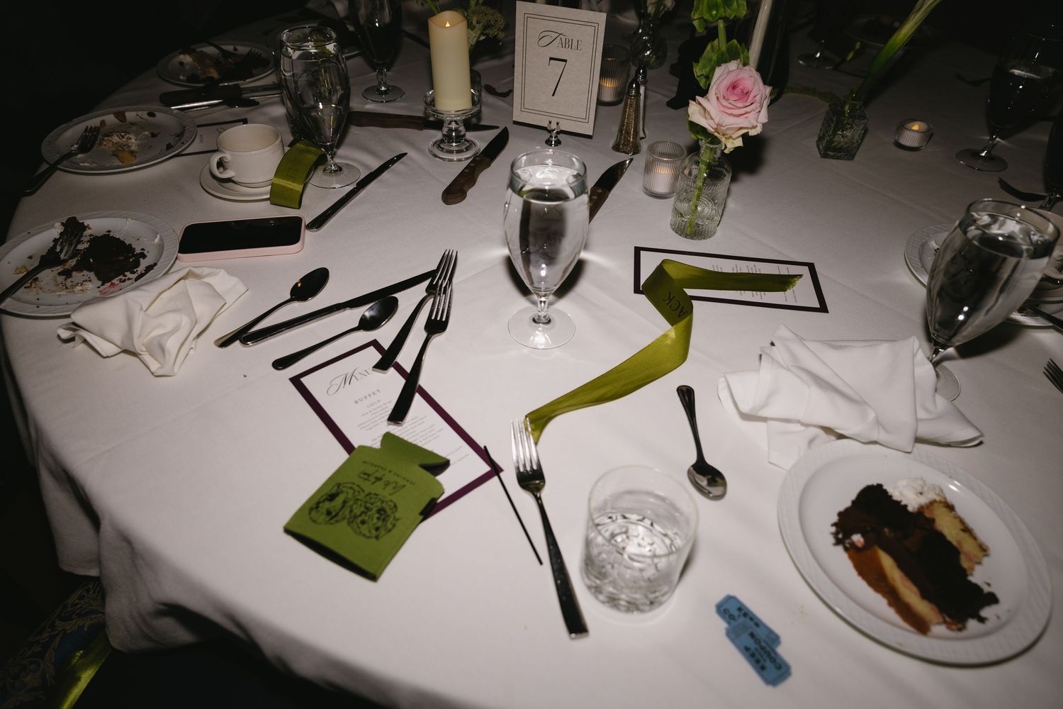 Wedding reception table settings with white linens and elegant place settings in a rustic venue.