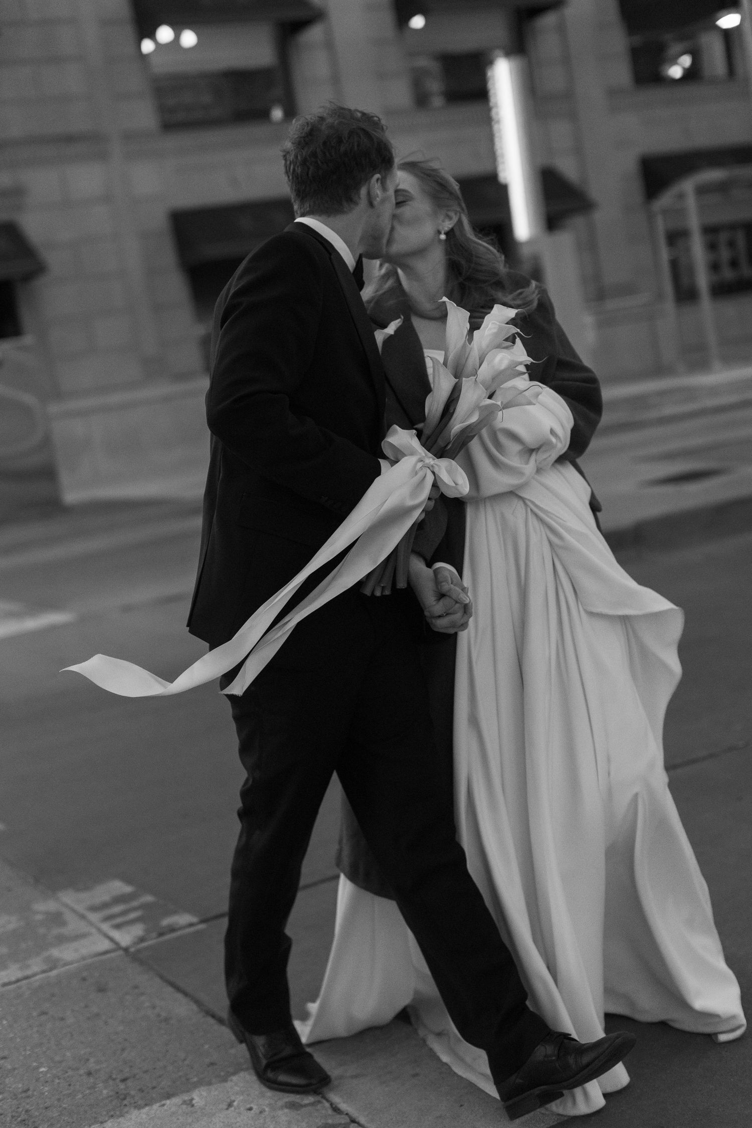 Black and white photos capture romantic dance moves between newlyweds on city streets.