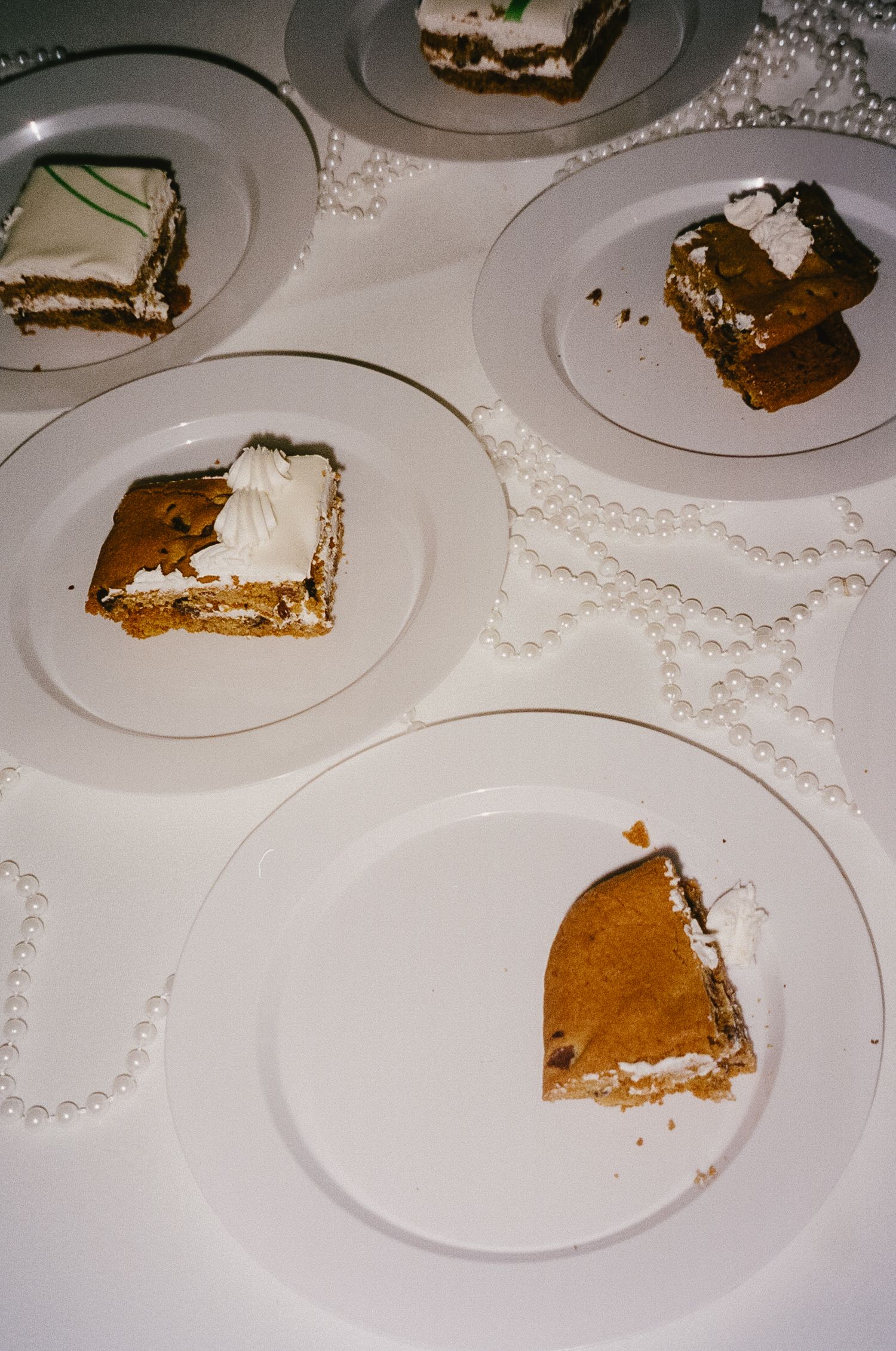 Partially eaten slices of pumpkin pie arranged on white plates with decorative pearl borders.