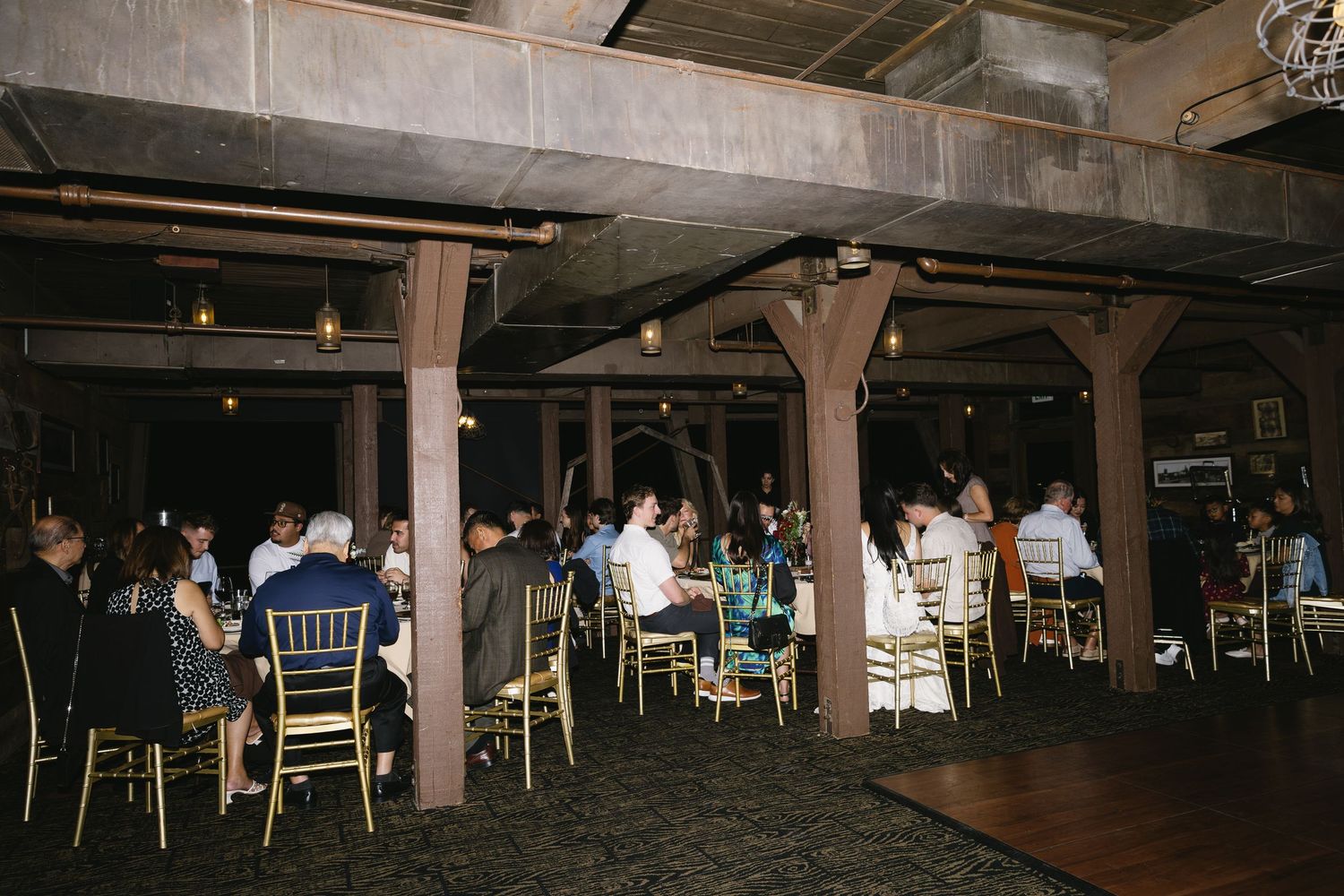 Interior view of a rustic wedding reception venue with tables and chairs set up.