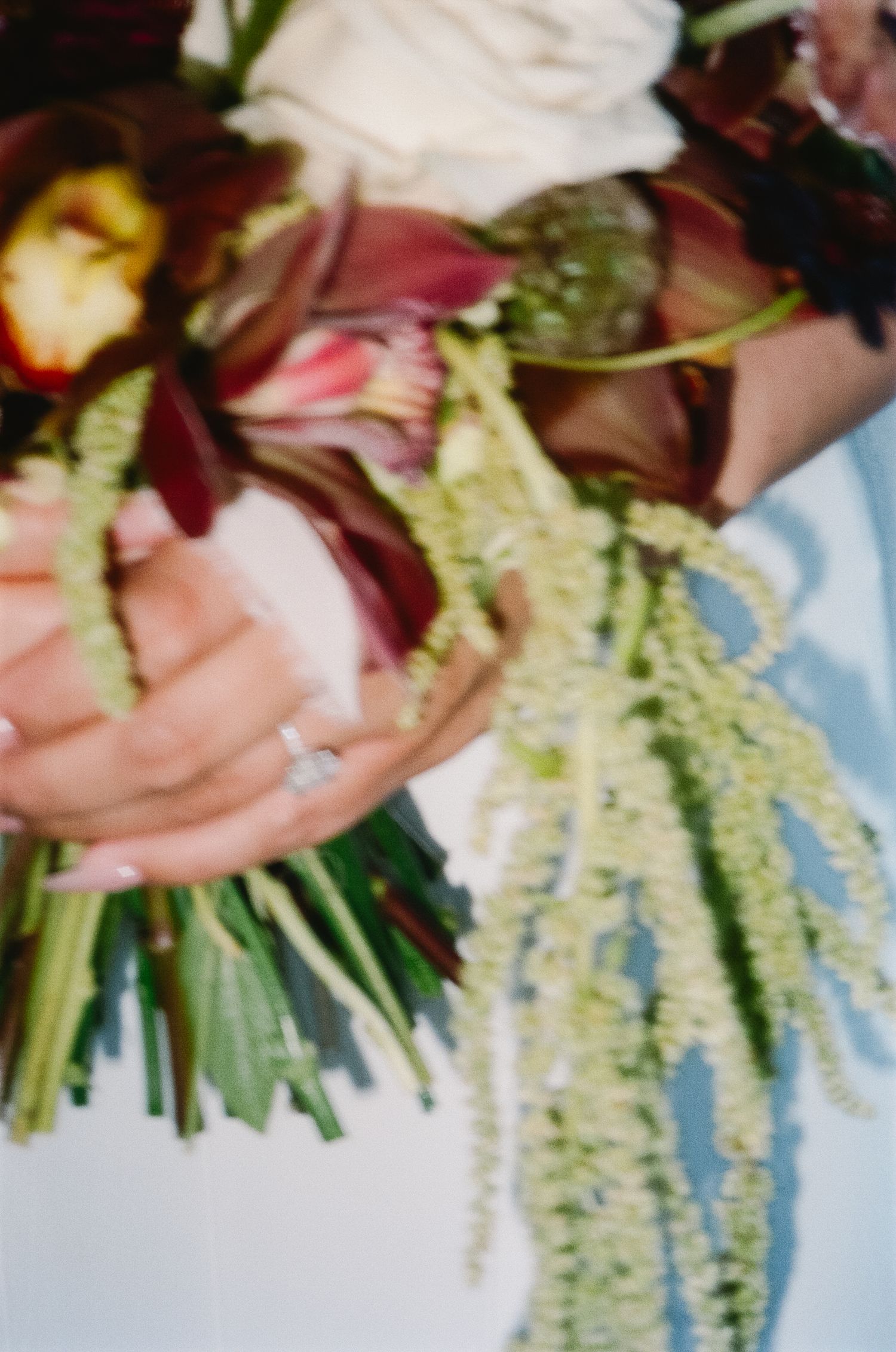 Close-up view of wedding bouquet flowers with cascading white floral arrangements and greenery.