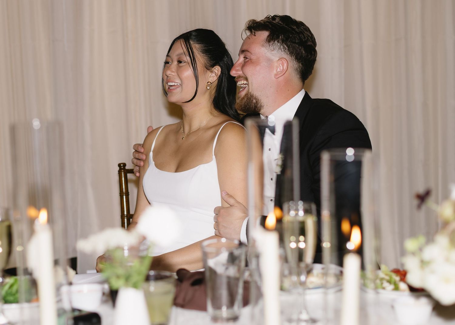 Reception venue decorated with elegant table settings and soft lighting for wedding celebration.