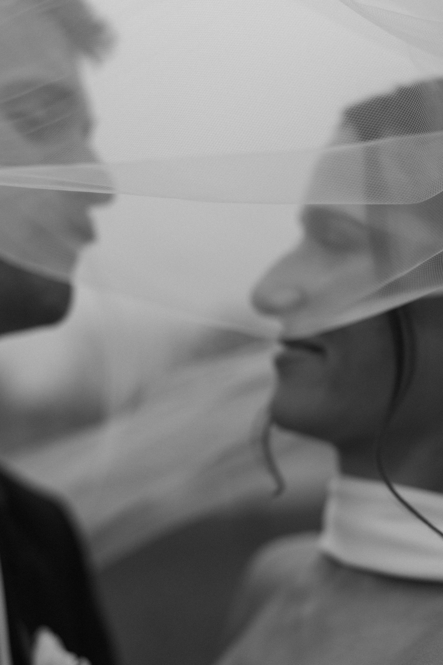 Ethereal wedding veil flowing in the breeze against a soft blurred background.