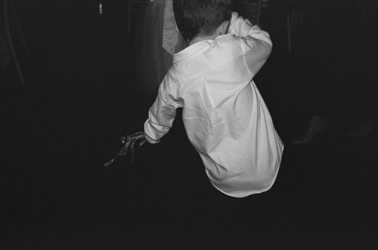 Black and white photo of someone dancing at a wedding reception.