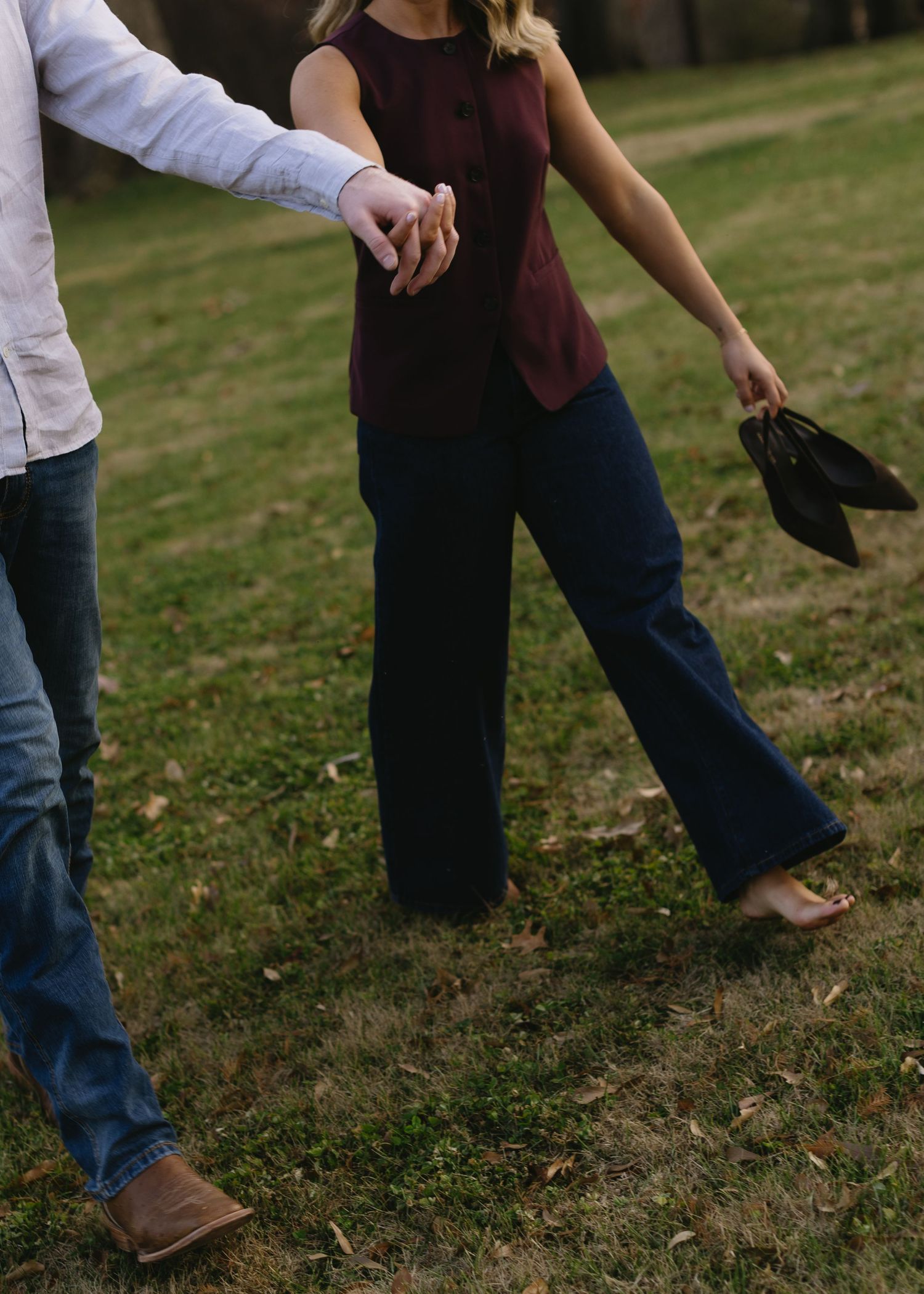 Close-up view of two people's feet standing together on grass.