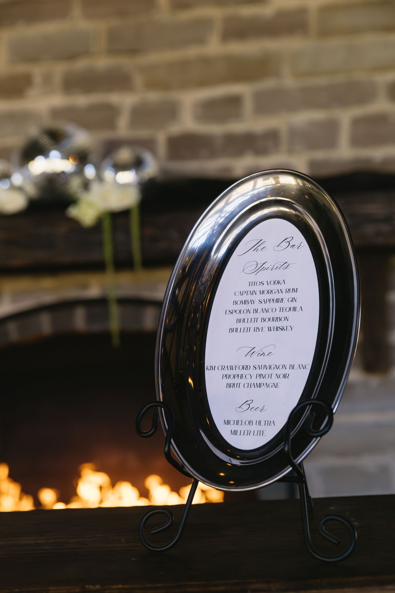 Black decorative plate holders displaying wedding menu cards with elegant text.