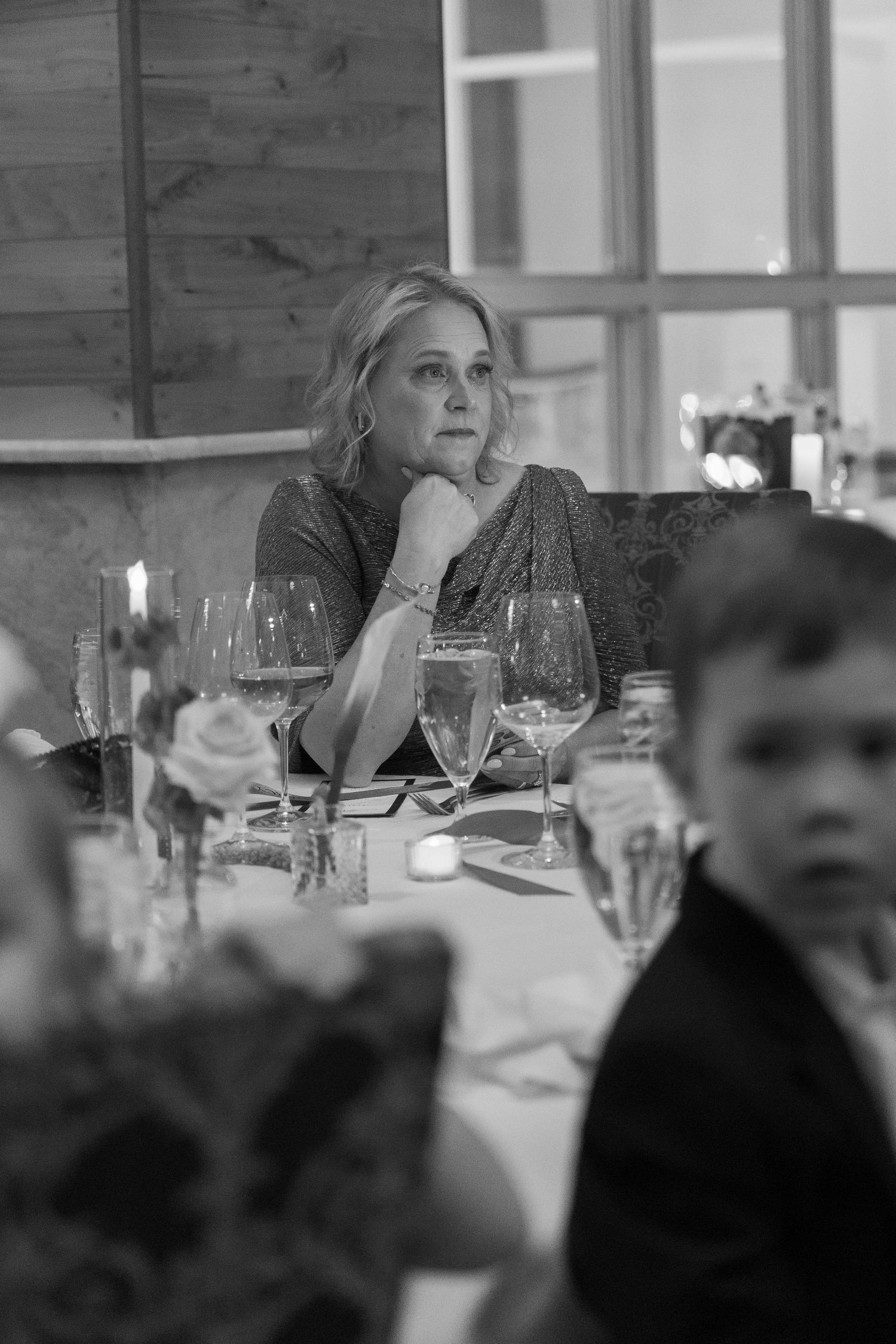Black and white reception candid showing table settings and guests.