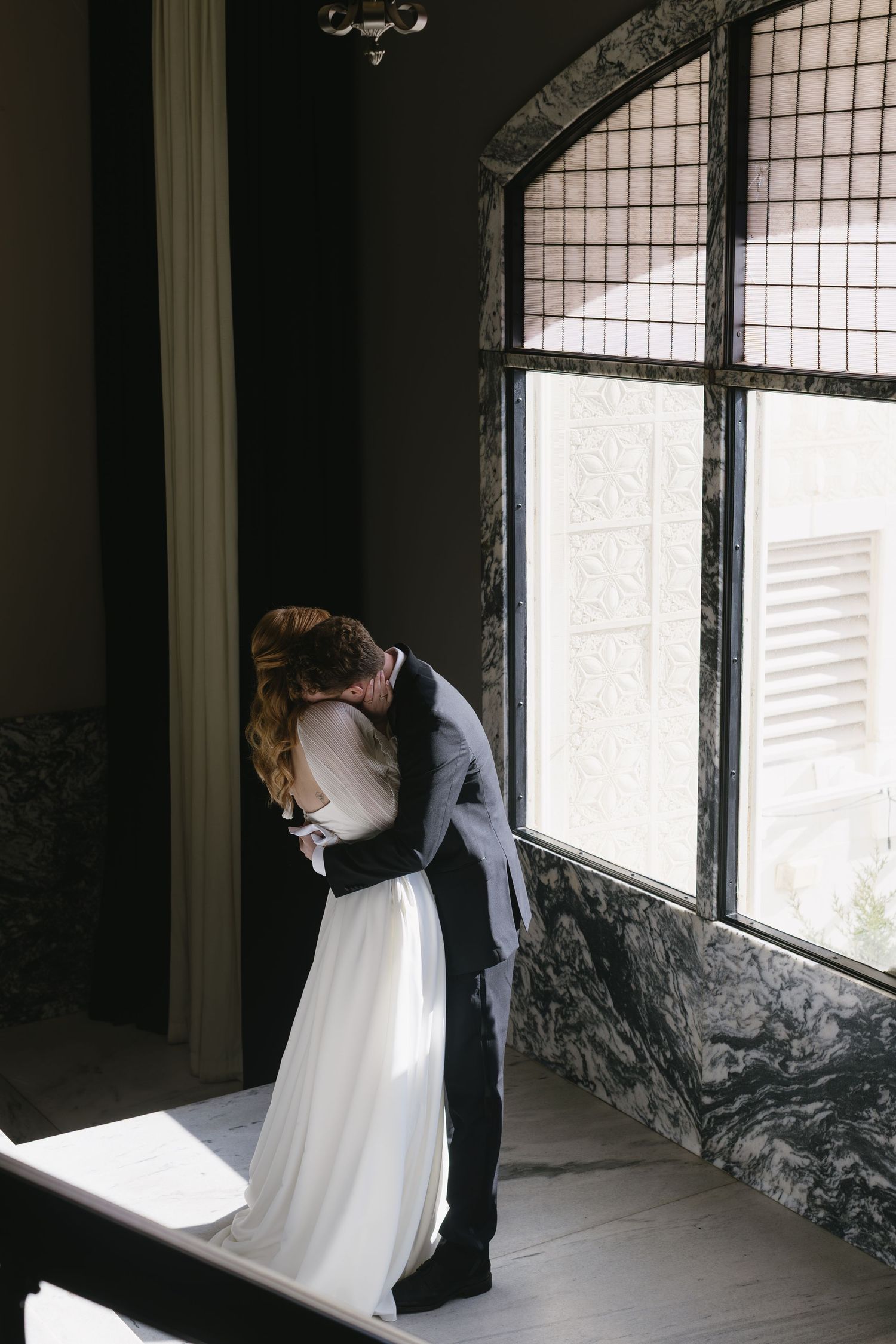 A series of romantic wedding photos showing a couple by a window in black and white.